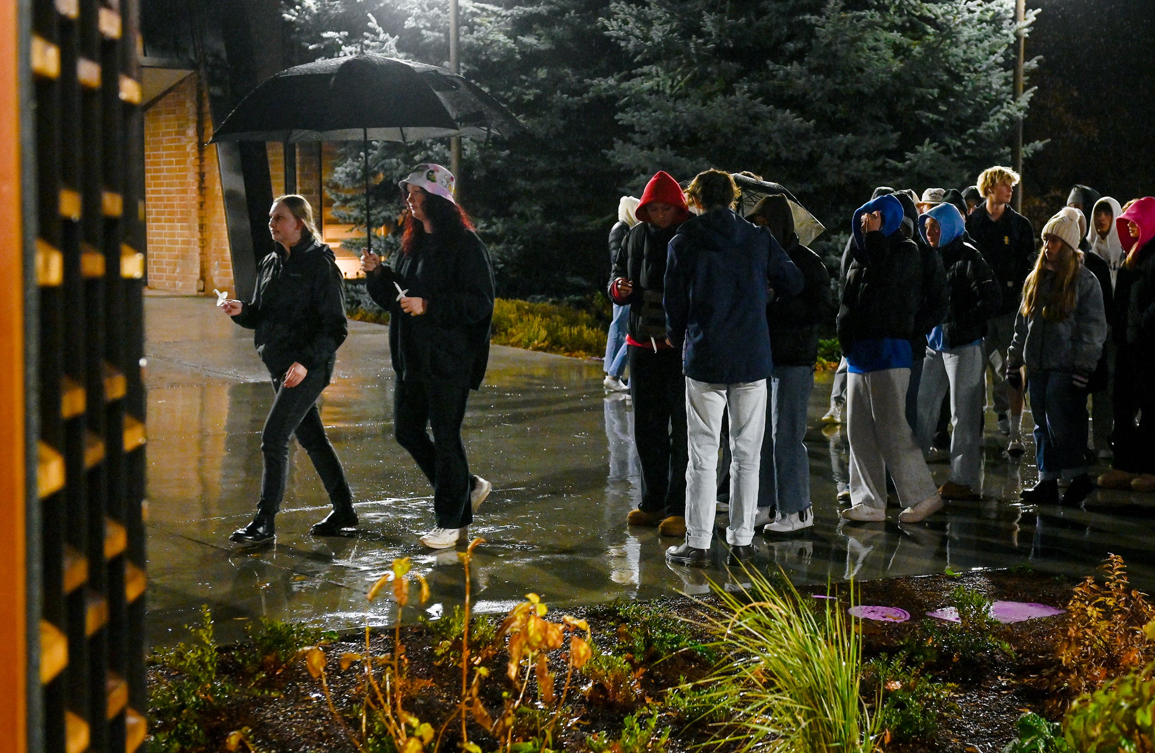 Those coming to the Vandal Healing Garden and Memorial for a vigil in remembrance of the four University of Idaho students murdered two years earlier are given candles as they walk in Wednesday in Moscow.