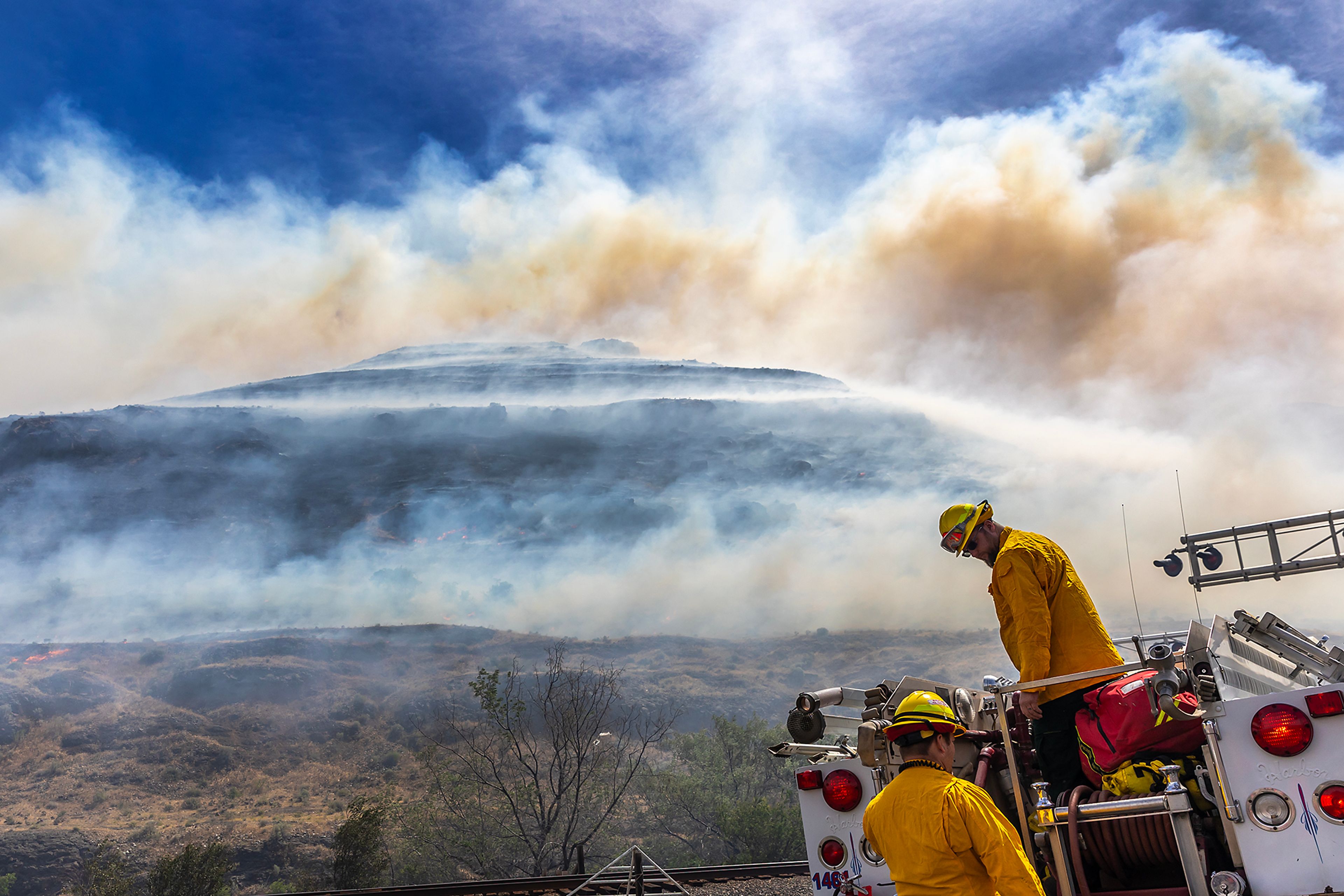 Firefighters work at the scene of a fire burning along the hills nearby Nisqually John Landing off of Wawawai Road on Friday.