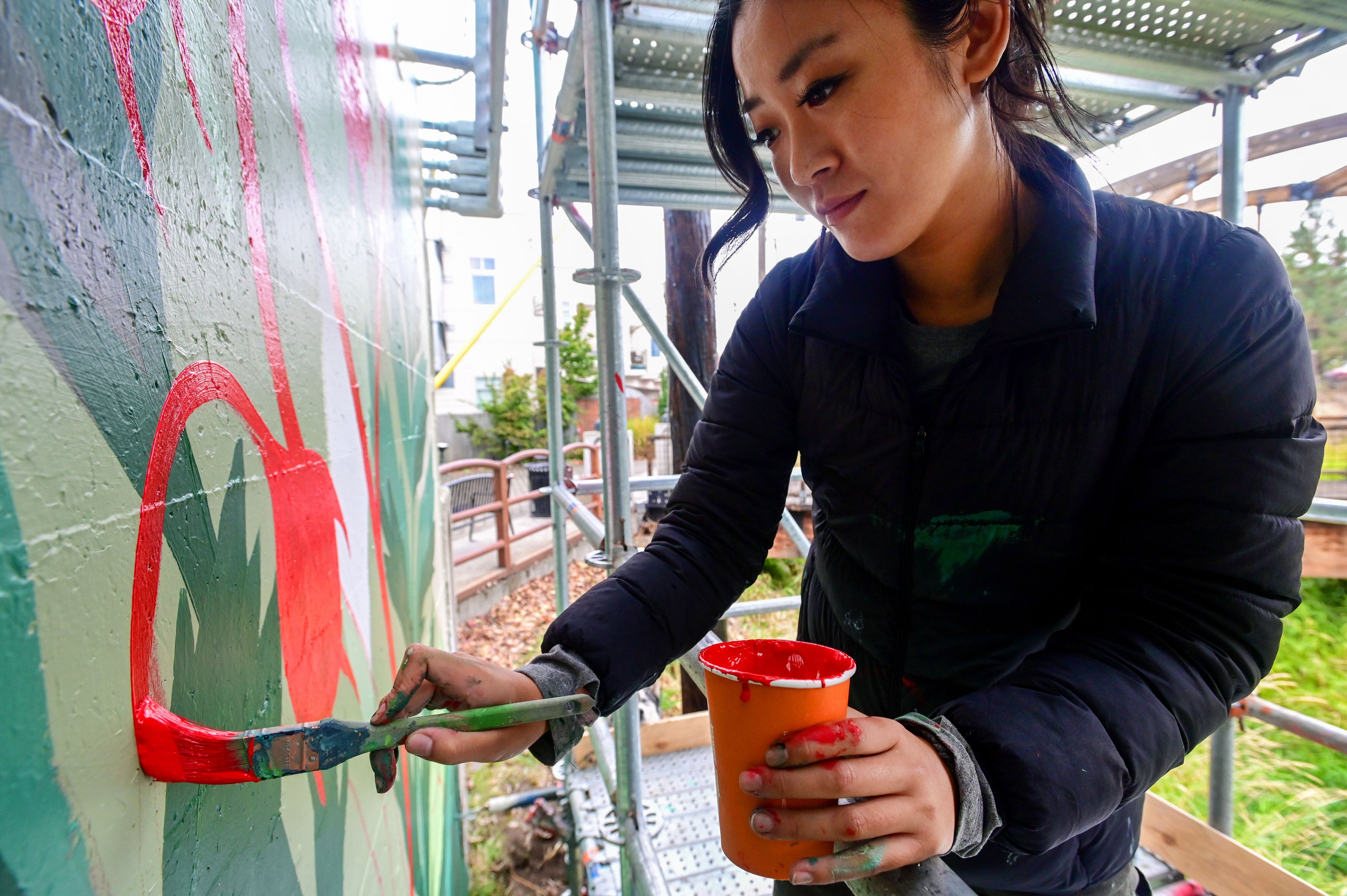 Tori Shao, an artist and landscape architect, works on a new mural in downtown Pullman.