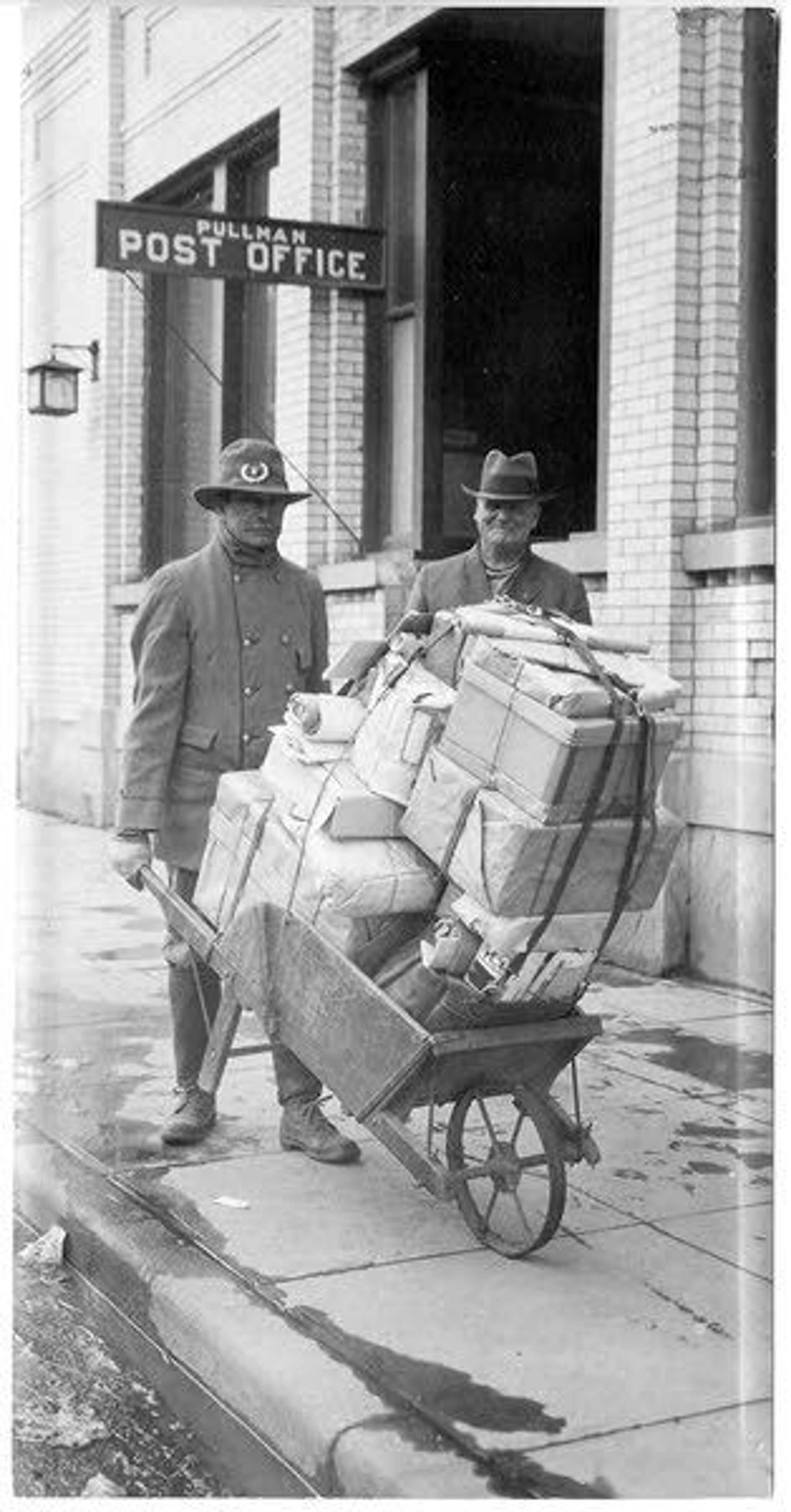 Washington State University Libraries, Manuscripts, Archives, and Special CollectionsPullman’s first mail carrier, W. H. Latta (1908-1931), with former postmaster E. W. Downen (1985-1989) is shown circa 1916.