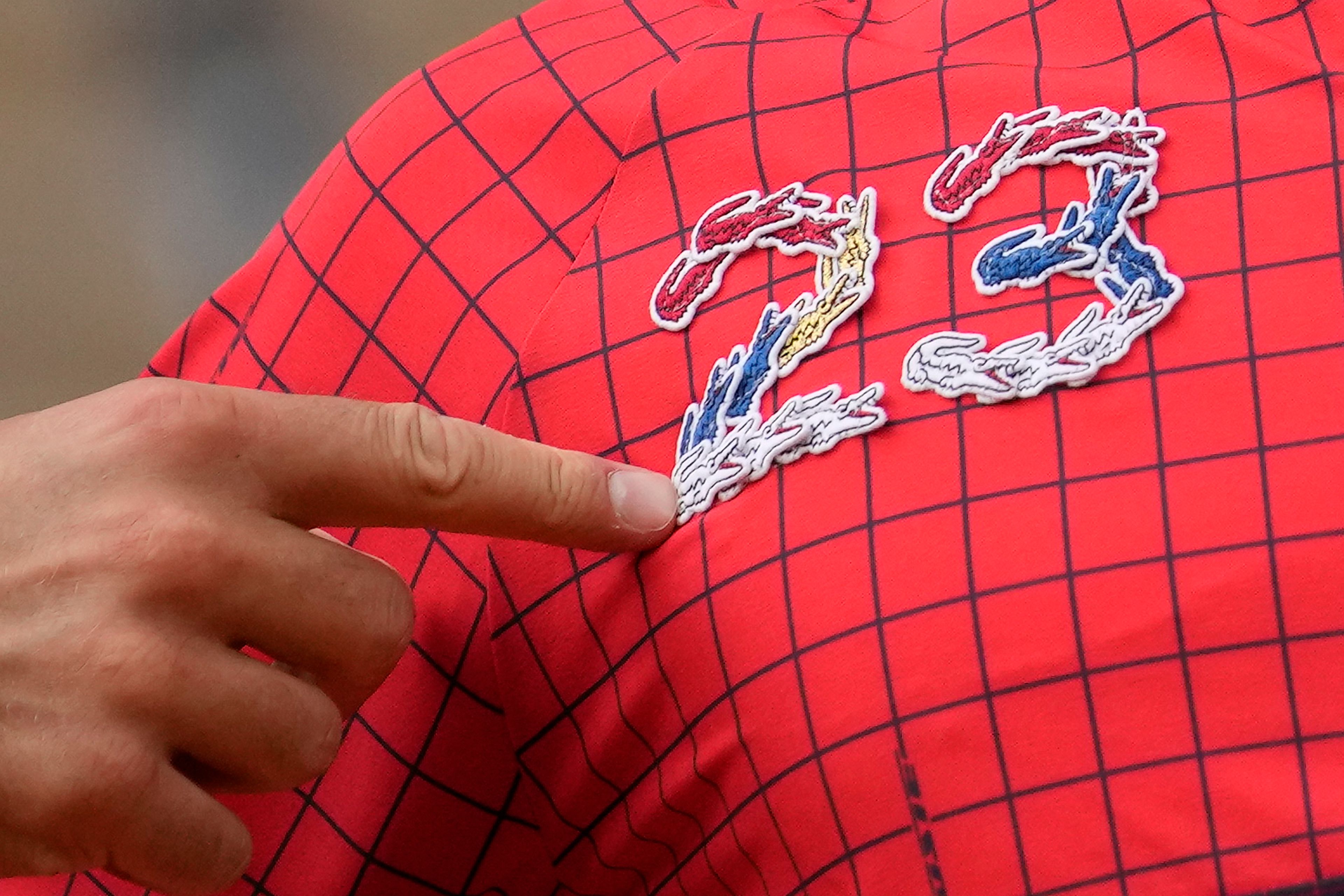 Serbia's Novak Djokovic points at 23 on his garment as he celebrates his record 23rd Grand Slam final after winning the men's singles final match of the French Open tennis tournament against Norway's Casper Ruud in three sets, 7-6, (7-1), 6-3, 7-5, at the Roland Garros stadium in Paris, Sunday, June 11, 2023. Djokovic won his record 23rd Grand Slam singles title, breaking a tie with Rafael Nadal for the most by a man. (AP Photo/Christophe Ena)