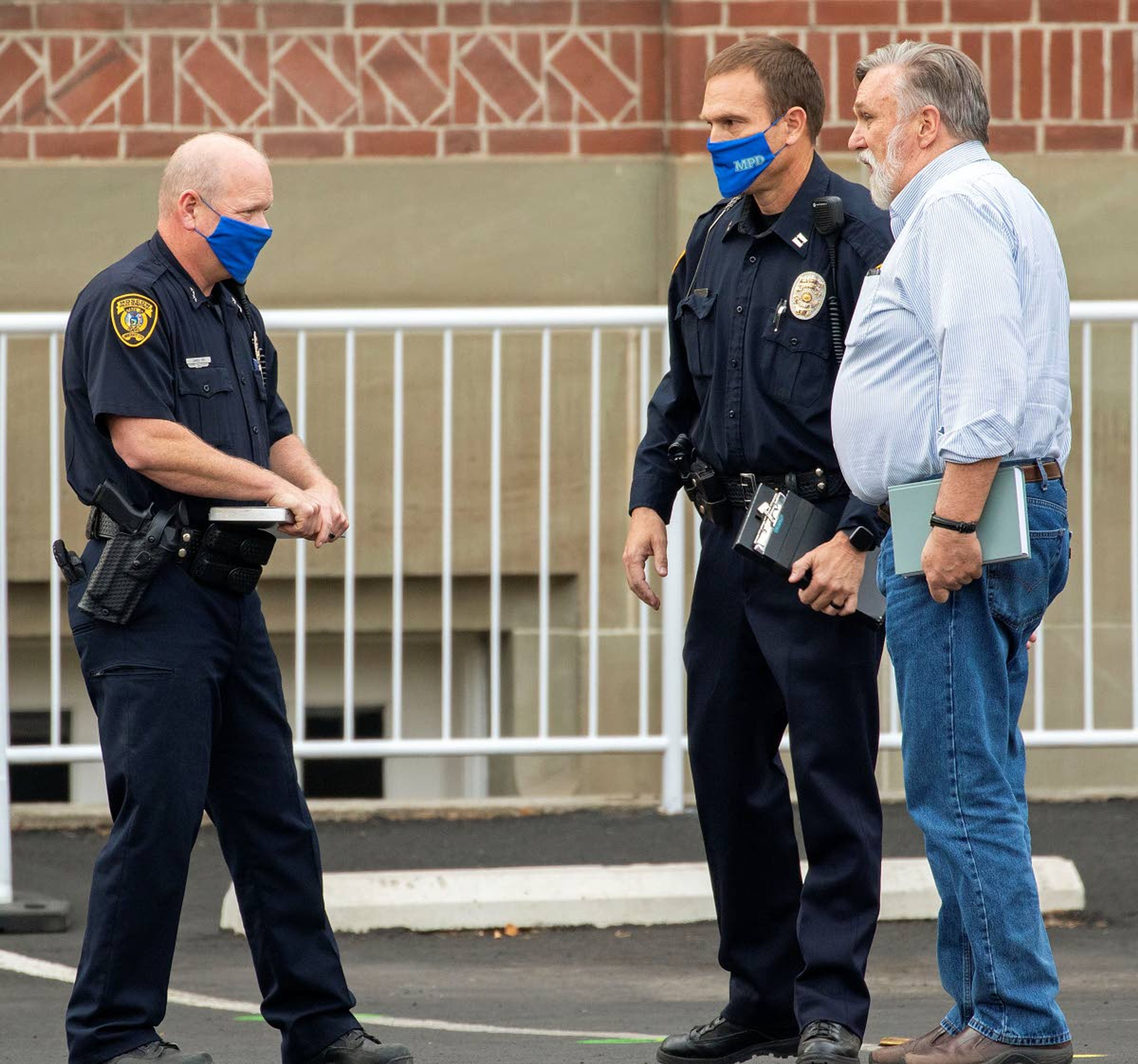 Geoff Crimmins/Daily NewsMoscow Police Chief James Fry, left, and Capt. Will Krasselt speak with Christ Church Pastor Doug Wilson before the church’s “psalm sing” Wednesday outside Moscow City Hall.