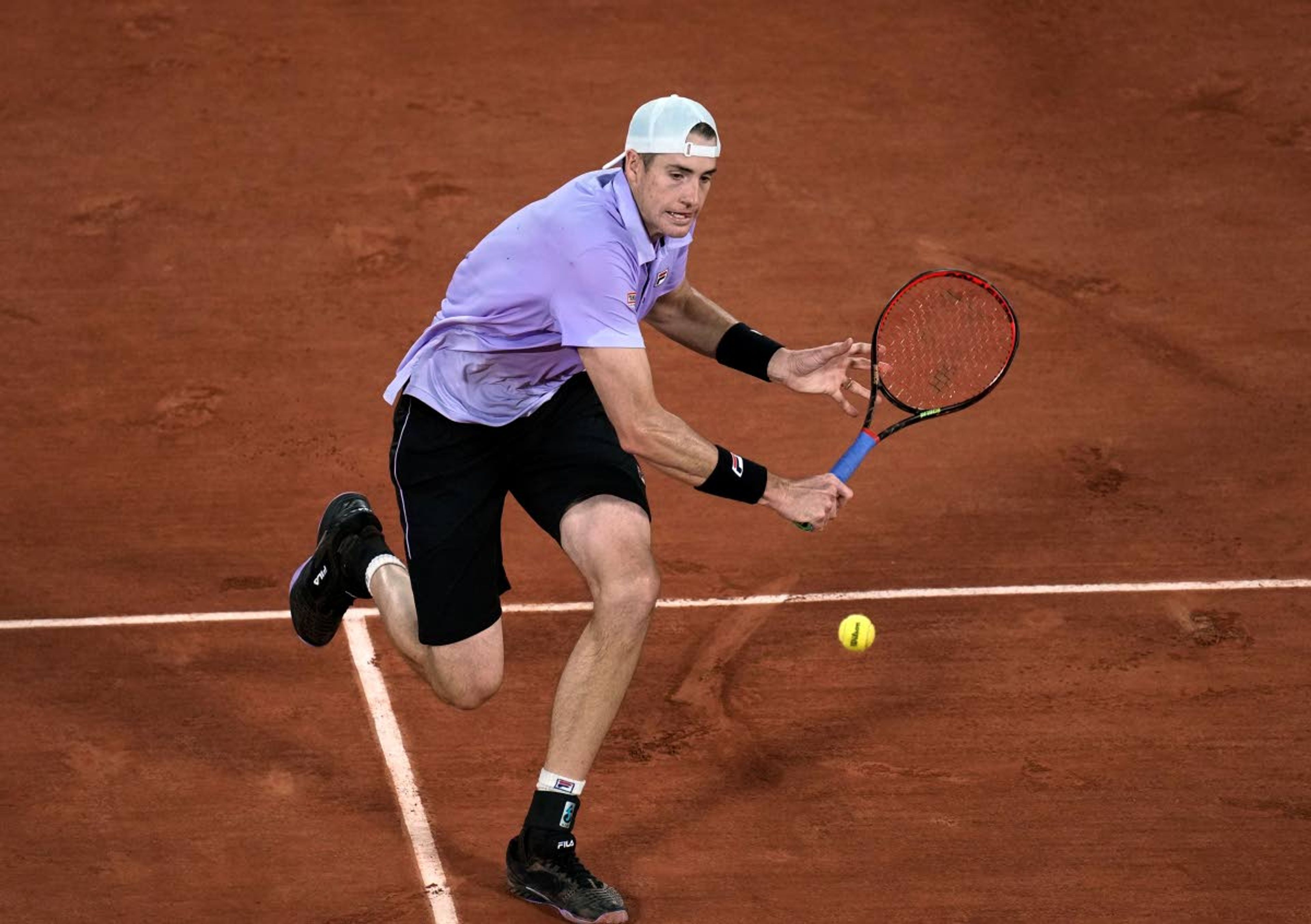 United States' John Isner plays a return to Stefanos Tsitsipas of Greeceday during their third round match on 6, of the French Open tennis tournament at Roland Garros in Paris, France, Friday, June 4, 2021. (AP Photo/Christophe Ena)