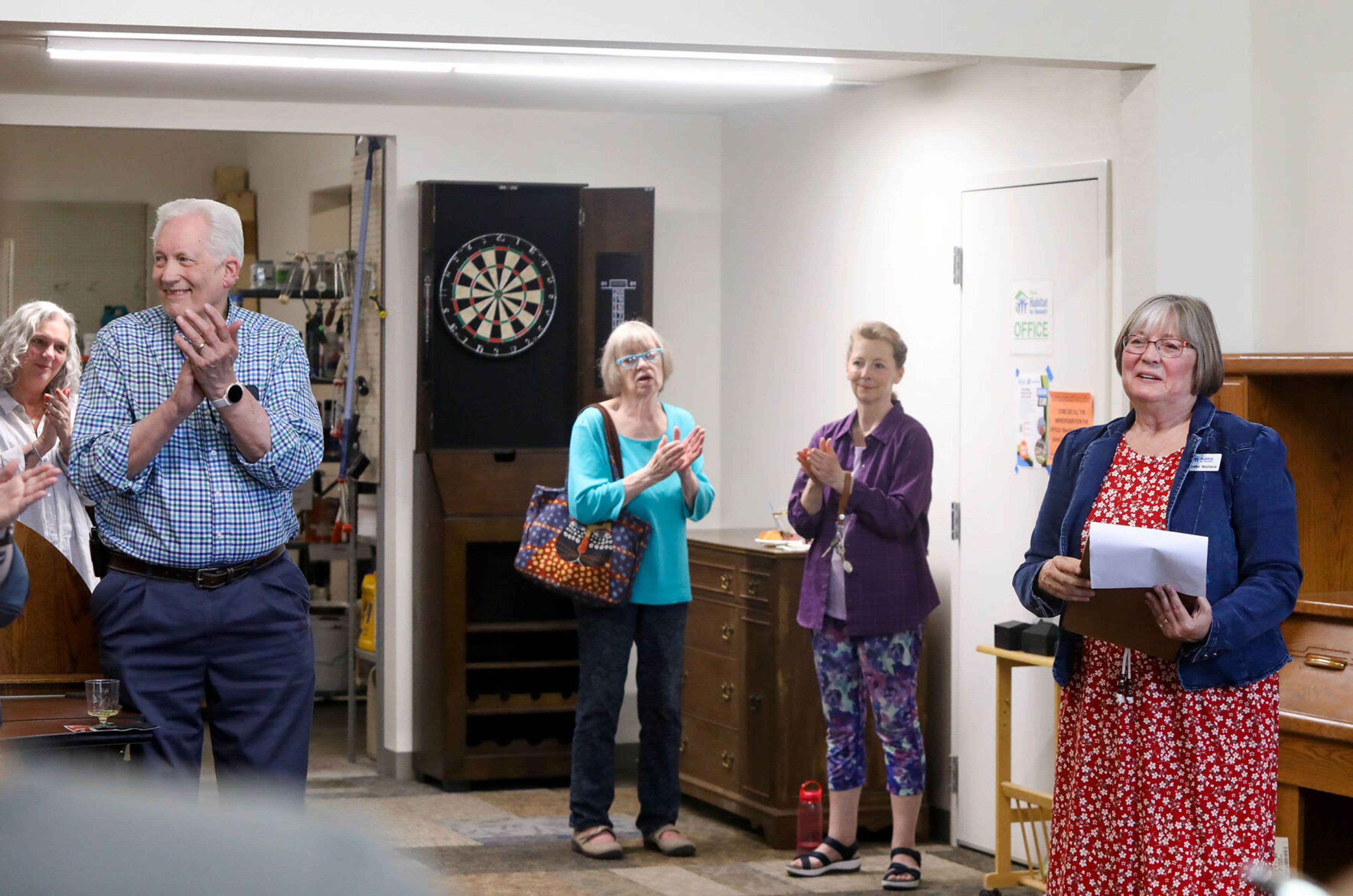 Those gathered to celebrate the grand reopening of the Palouse Habitat for Humanity ReStore clap as PHFH executive director Jennifer Wallace, right, highlights supporters of the five-year endeavor in Moscow on Thursday.