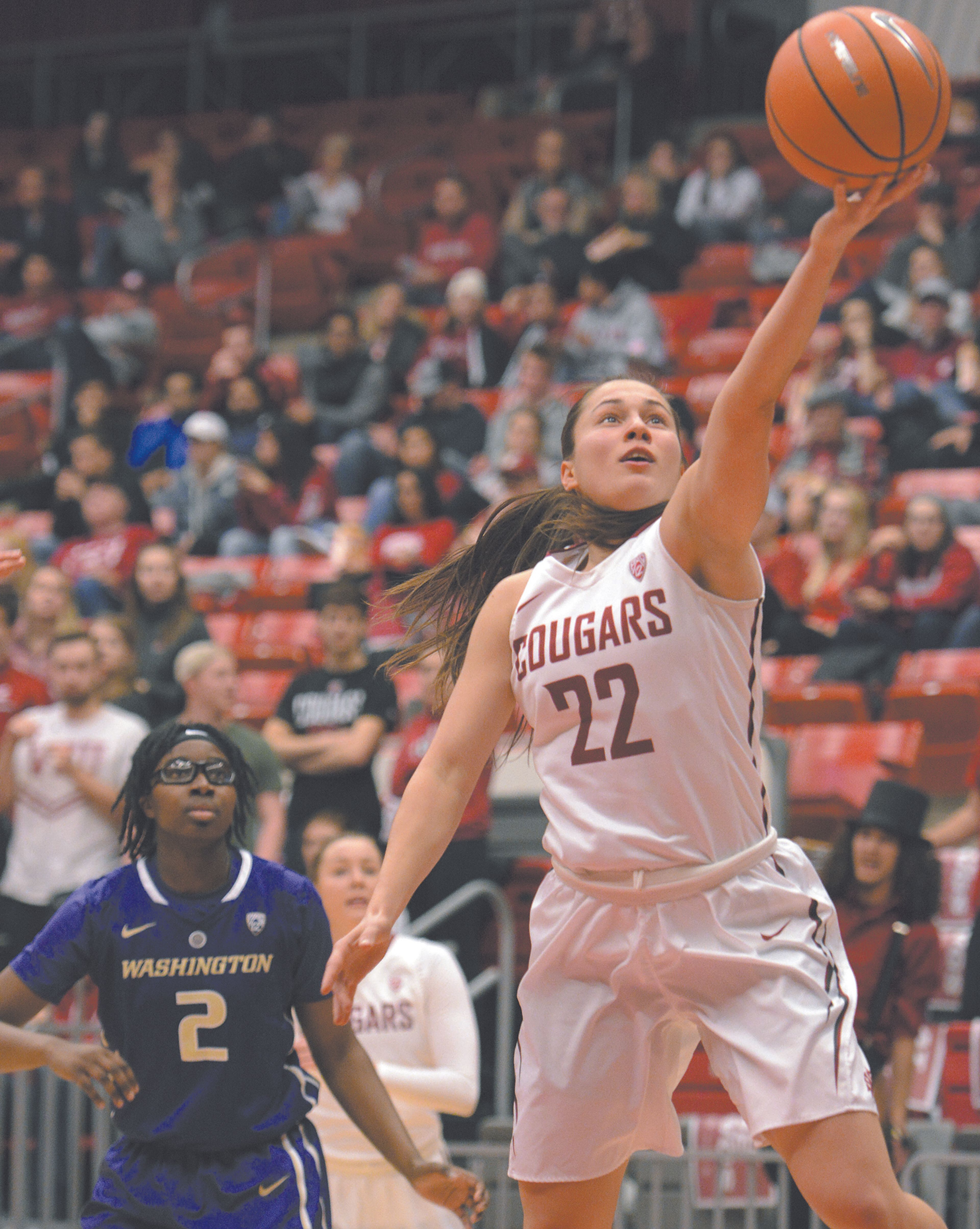 Washington State guard Pinelopi Pavlopoulou (22) drives to the basket as Washington's forward Fapou Semebene (2) looks on during the first half of an NCAA basketball game Wednesday in Pullman, Wash.