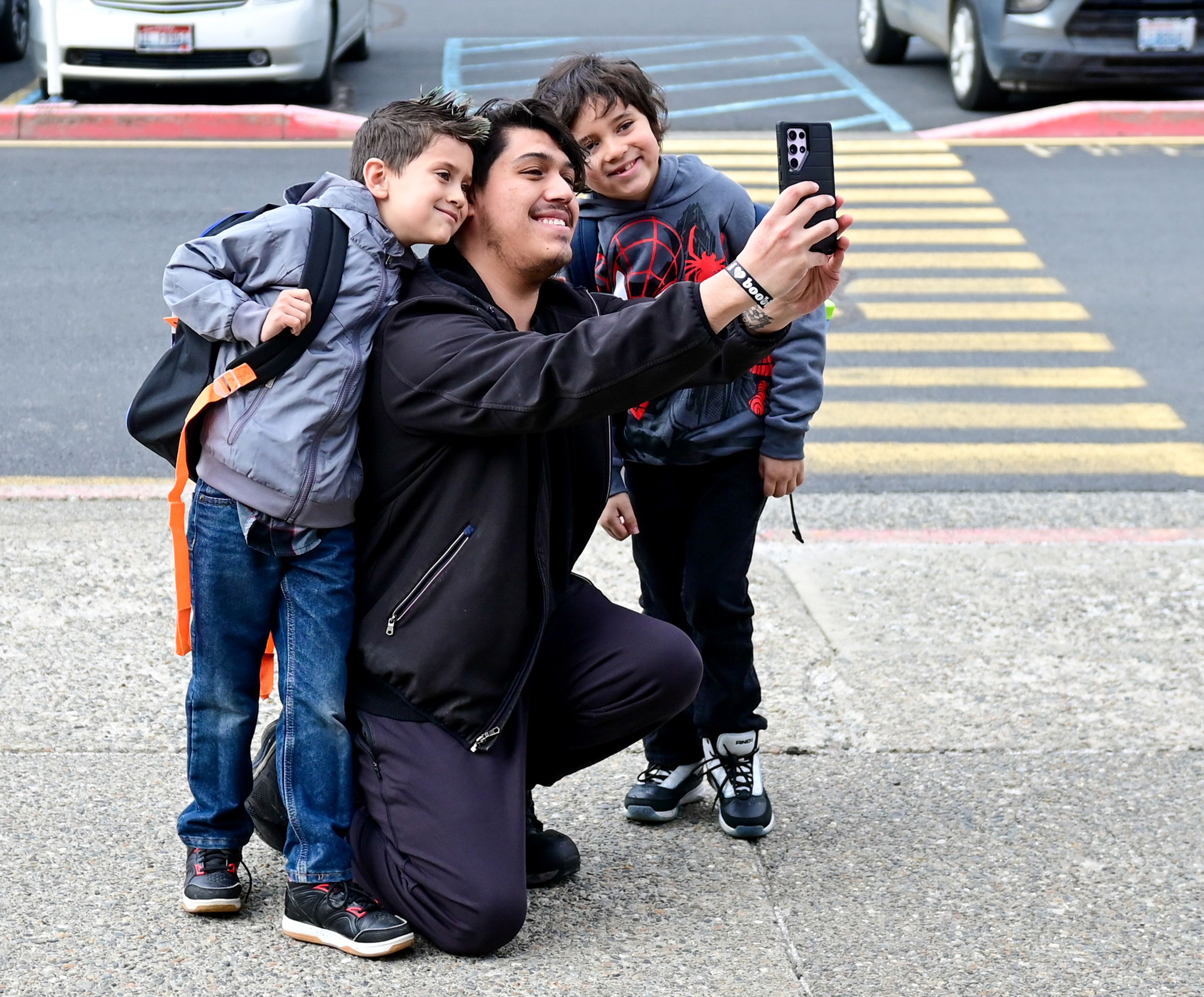 Miguel Hernandez takes a selfie with Monroe, left, and Bastian, right, 6-year old cousins, before their first day of school at Jefferson Elementary School on Wednesday in Pullman.