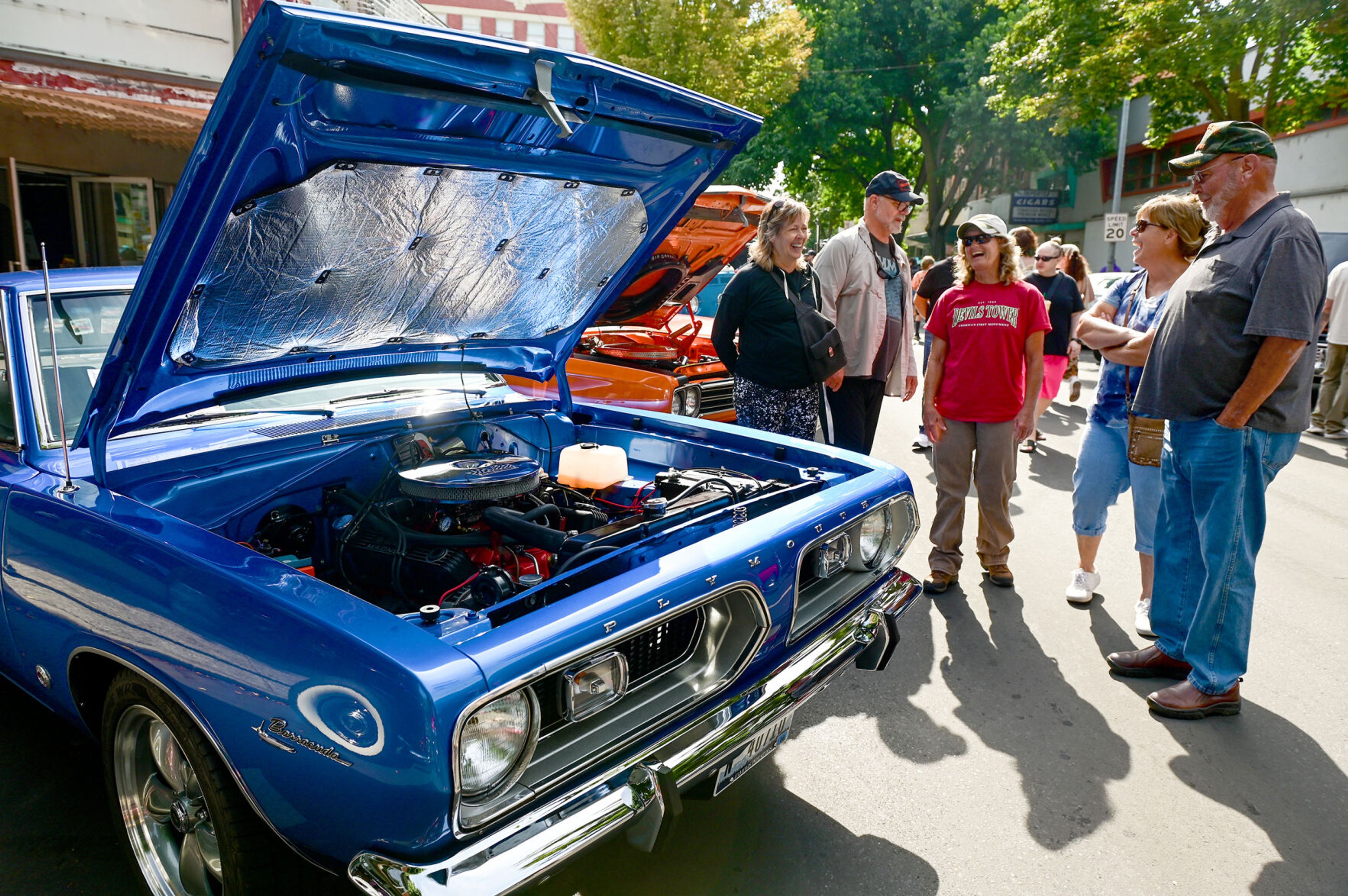 Stephanie Hetrick, from left, Nicholas Hetrick, Karla Bing, Sarah Boesen and Terry Thomas talk as they walk between cars on display along Main Street for Lewiston Hot August Nights on Saturday.