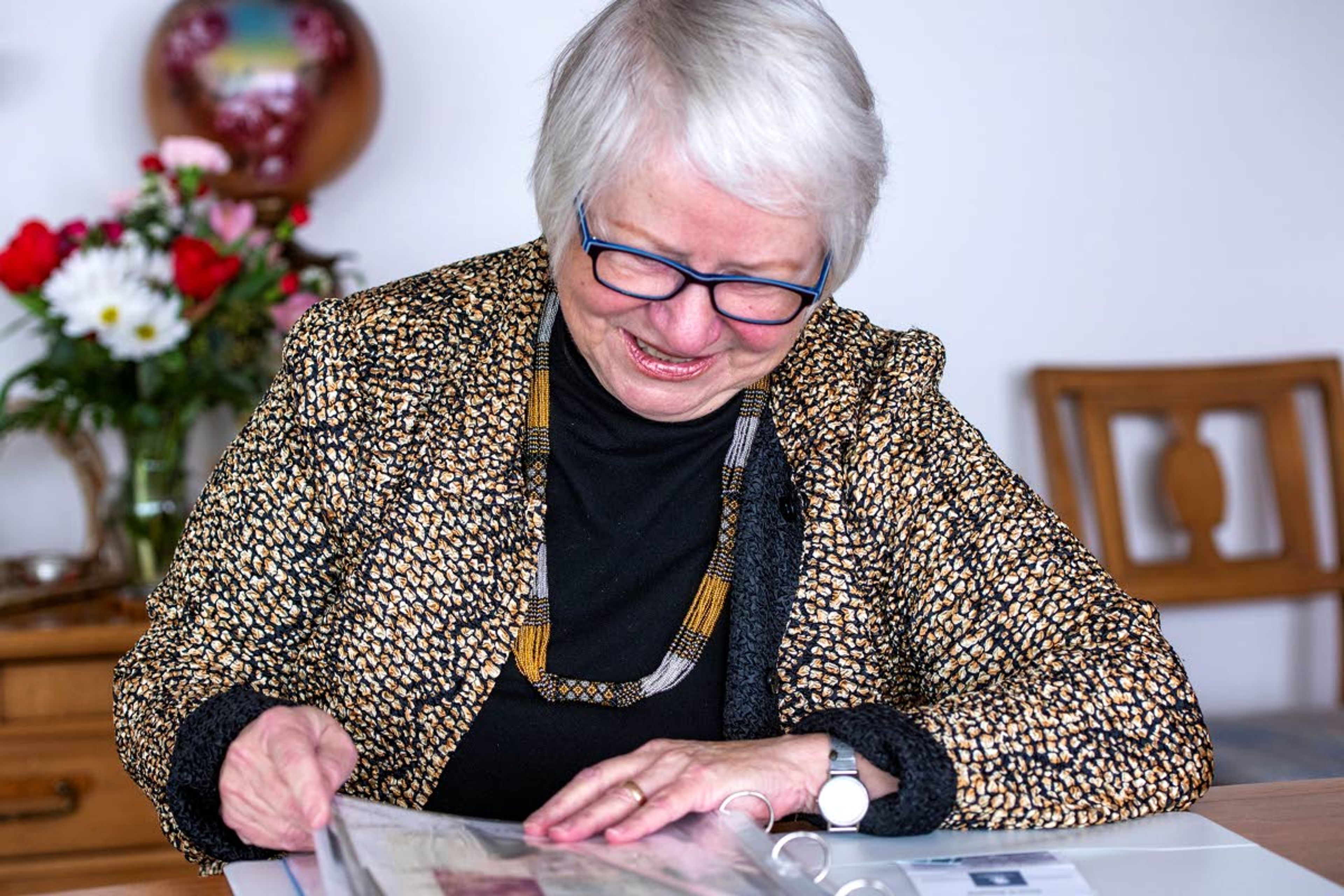 Former mayor of Pullman Karen Kiessling looks through a scrapbook containing letters from her friends in the community at the dining room table at her home Friday afternoon. Kiessling was hindered from celebrating her 80th birthday with friends and family Wednesday, so she adapted by sending a letter to 10 female friends that contained $80 to spend whichever way they deemed necessary, with the only request being that they must reply with how they chose to spend the money.