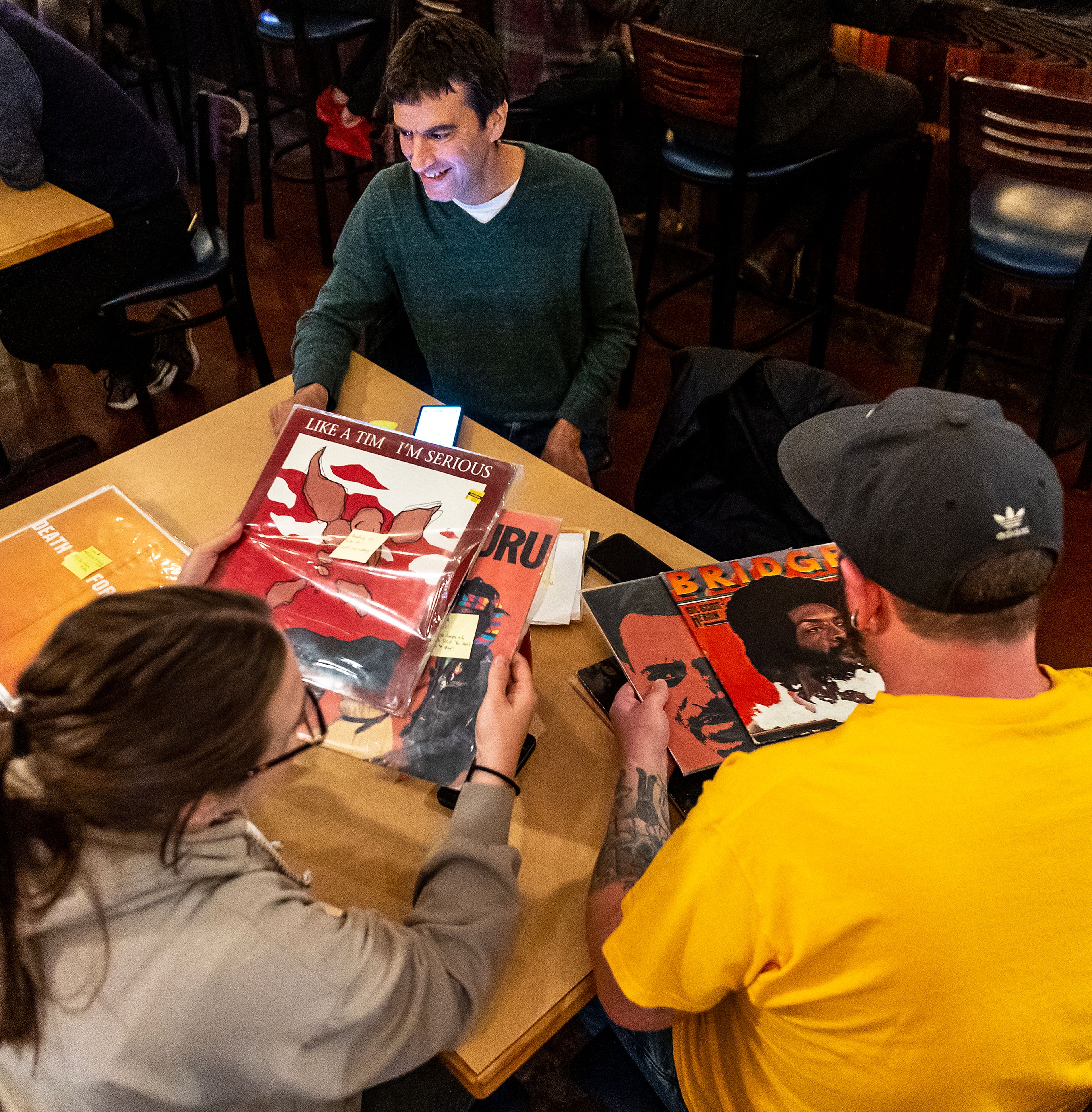 Chelsea Hufford, left, Darrell Sanson, right, both of Moscow, and David Lustig, of Colfax, look over the vinyls they brought for Bring Your Own Vinyl Night Wednesday at Moscow Brewing Company.