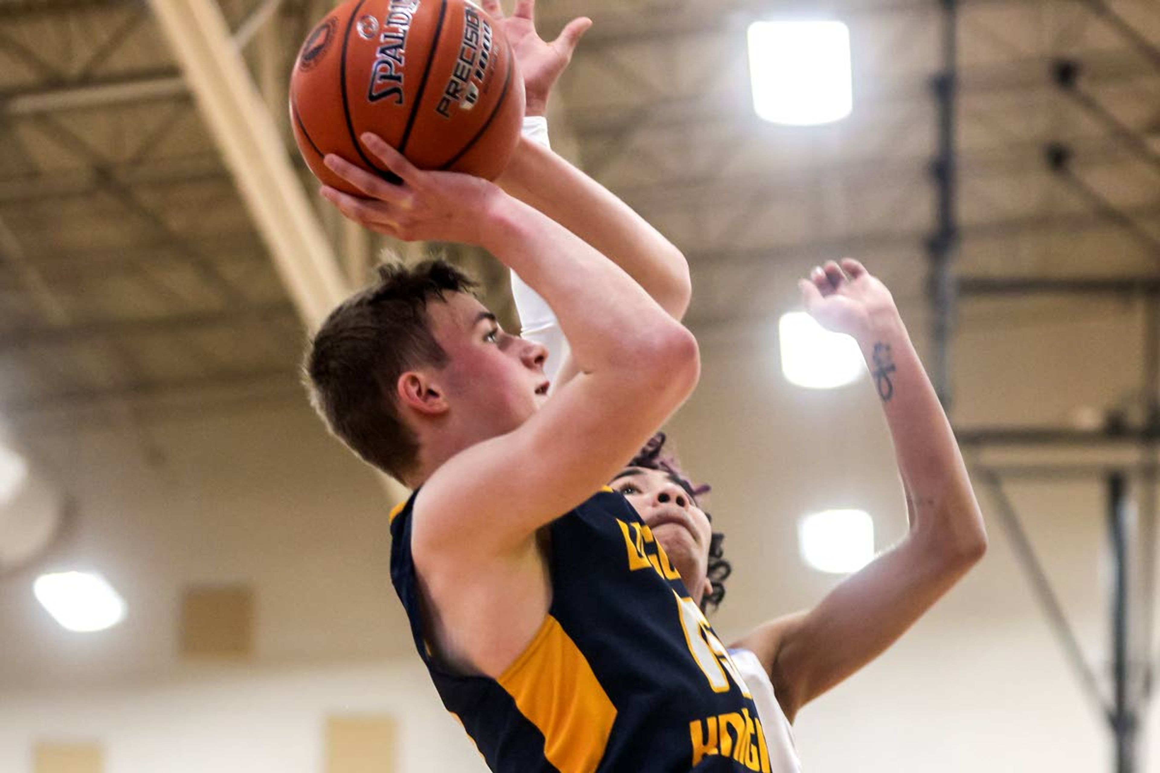 Logos Seamus Wilson prepares to take a shot before Lapwai guard Terrell Ellenwood-Jones blocks it during round two of the Idaho High School boys state basketball tournament at Vallivue High School on Friday.