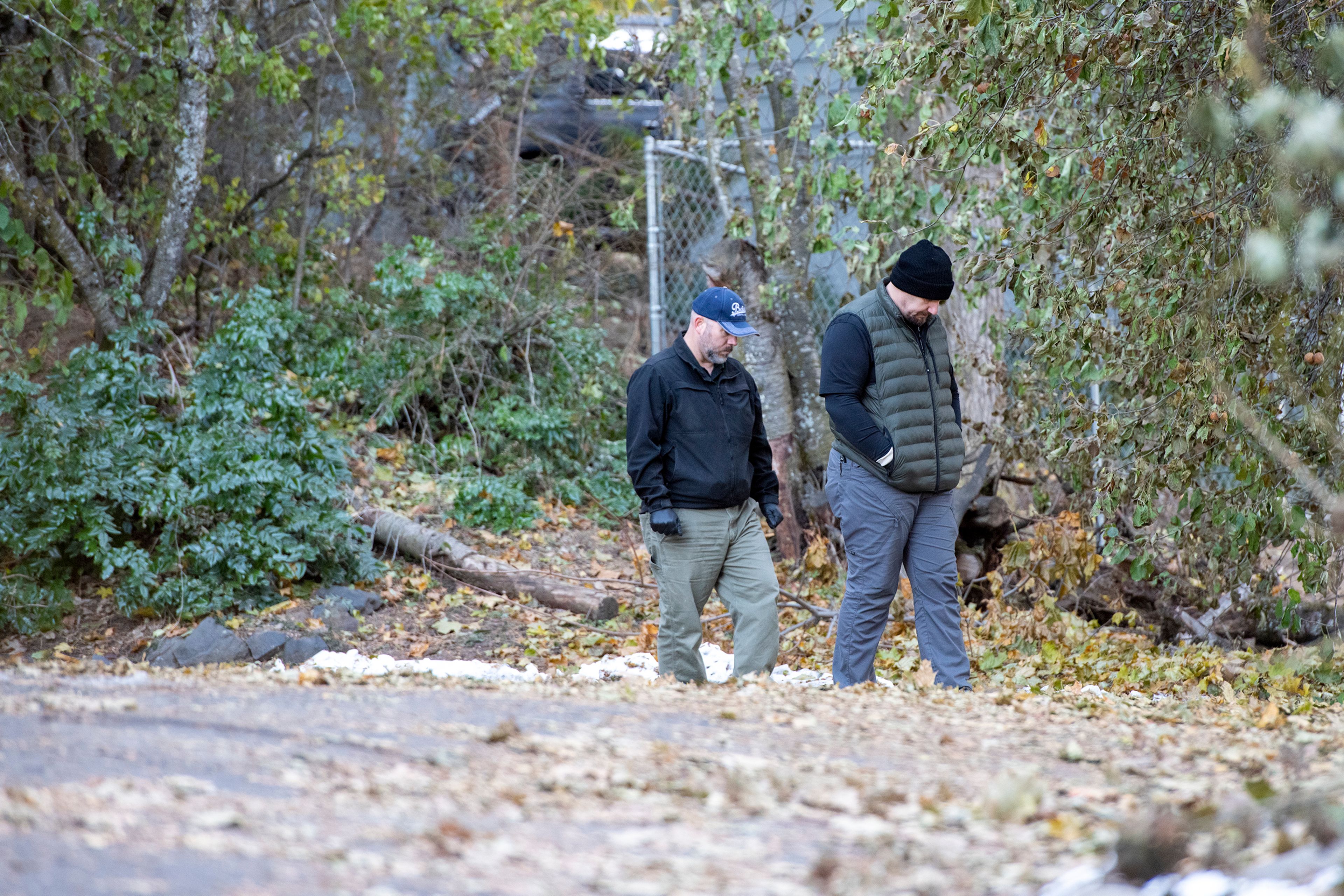 Officers investigate Monday in a parking lot behind the home where four University of Idaho students were stabbed in a quadruple homicide on King Road in Moscow.