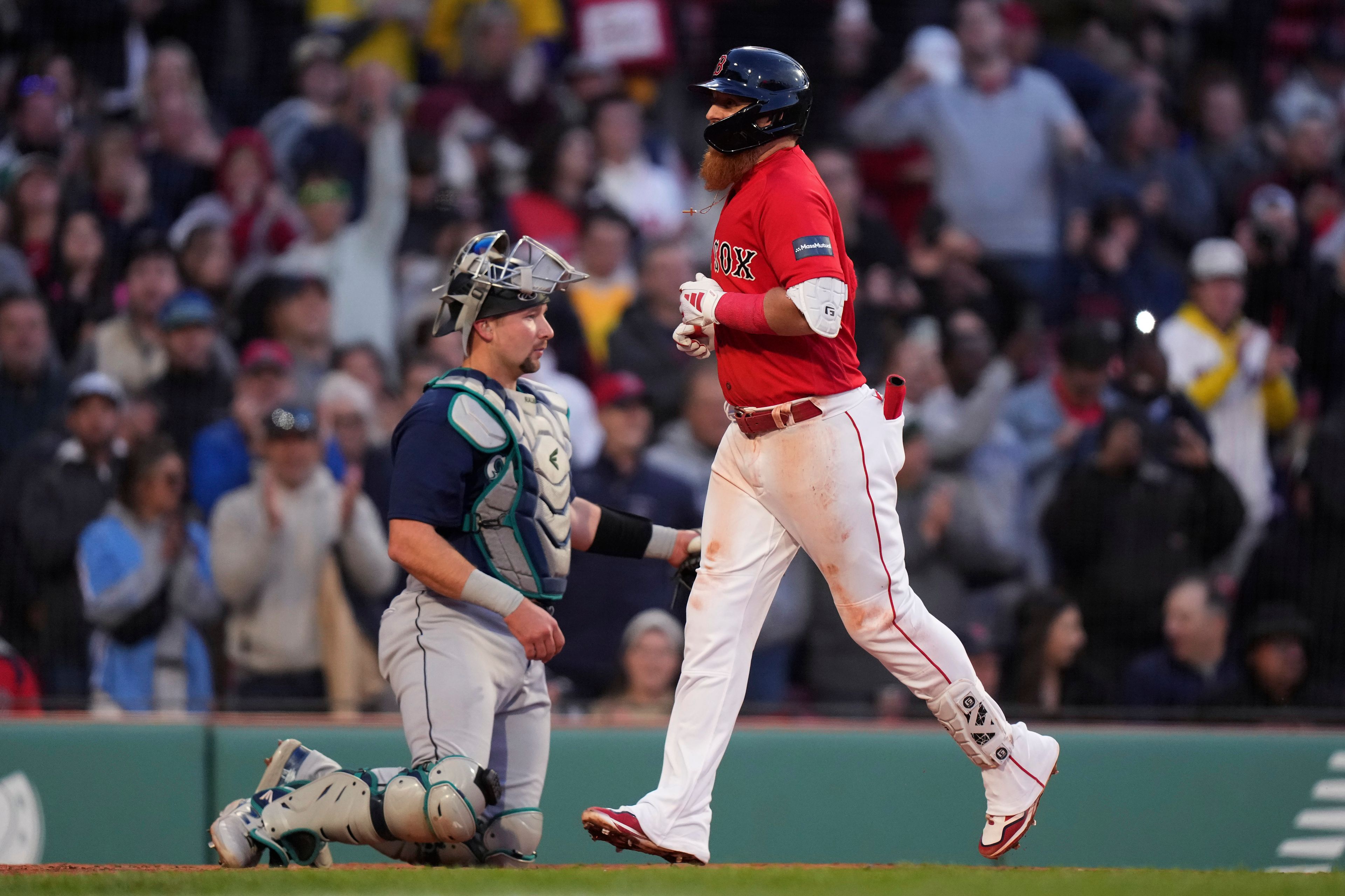 Boston Red Sox's Justin Turner, right, arrives at home plate in front of Seattle Mariners' Cal Raleigh, left, to score on his two-run home run during the second inning of a baseball game Wednesday, May 17, 2023, in Boston. (AP Photo/Steven Senne)