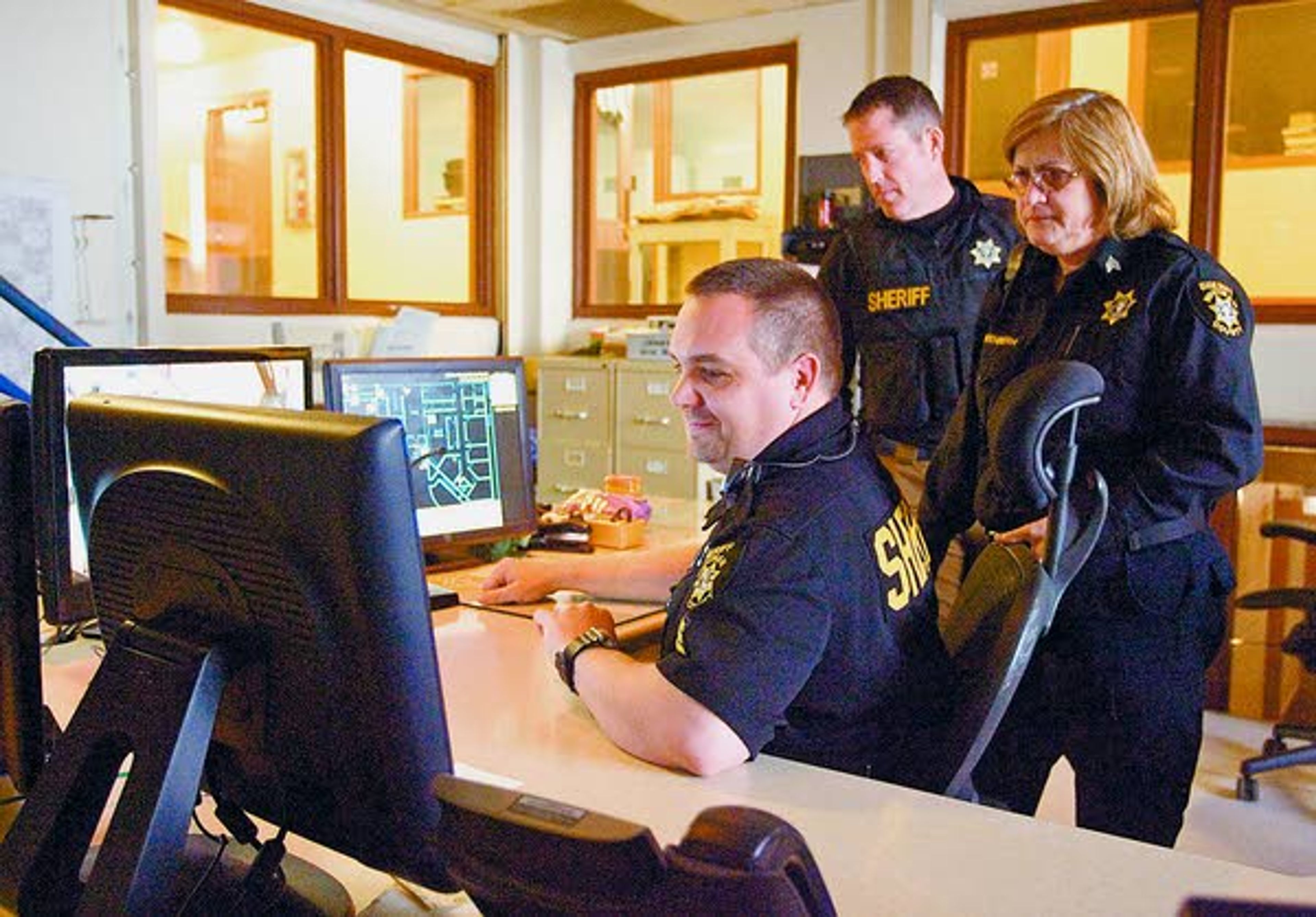 Sgt. Sam Keller (left to right), Sheriff Brett Myers and Sgt. Toni Poffenroth talk in the control room of the Whitman County Jail in Colfax on Tuesday.