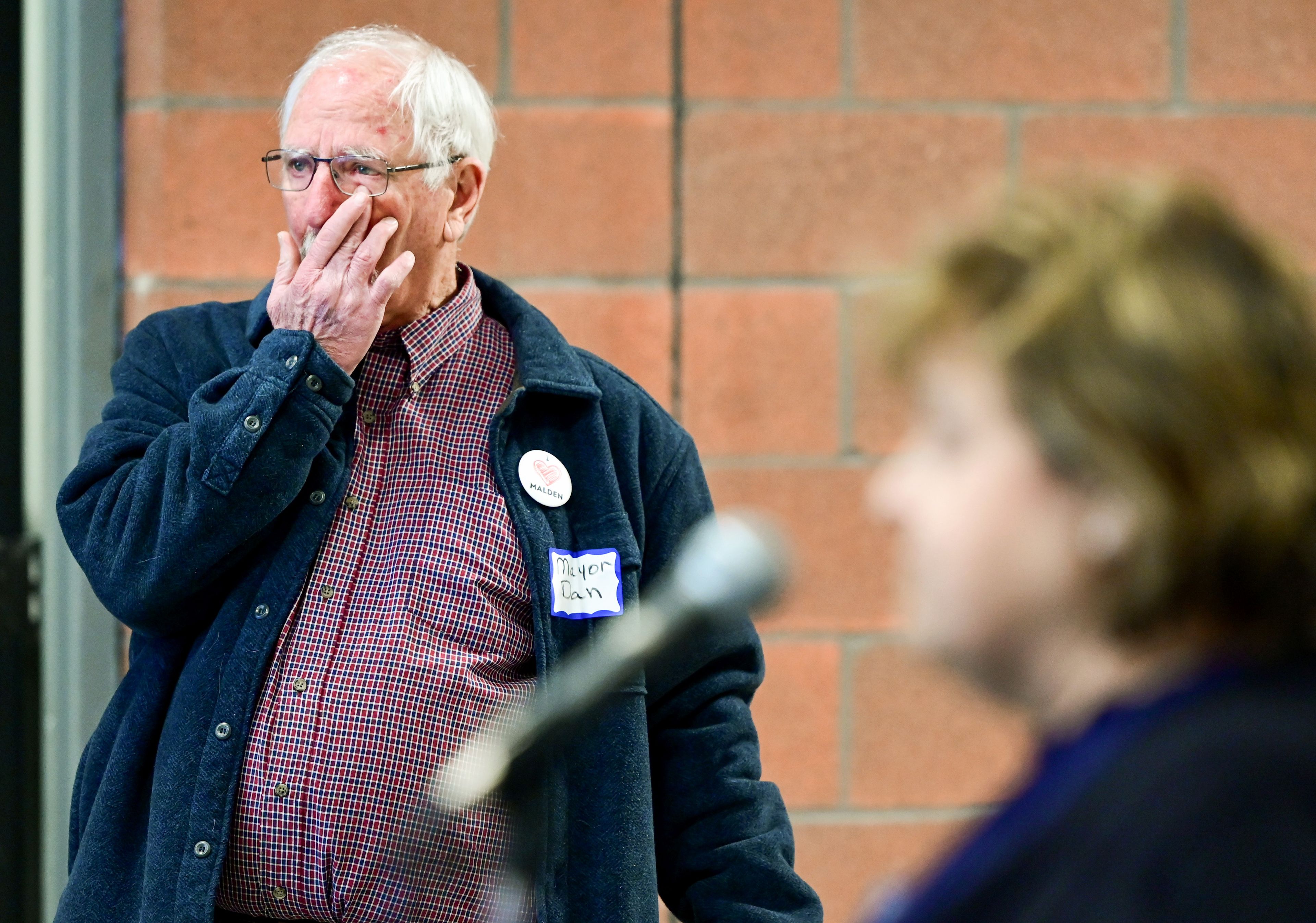 Malden Mayor Dan Harwood, left, wipes tears from his eyes as city clerk Micki Harnois welcomes those gathered for a ribbon cutting at the city’s new facilities on Thursday. The building will serve as a post office, fire station and town hall.