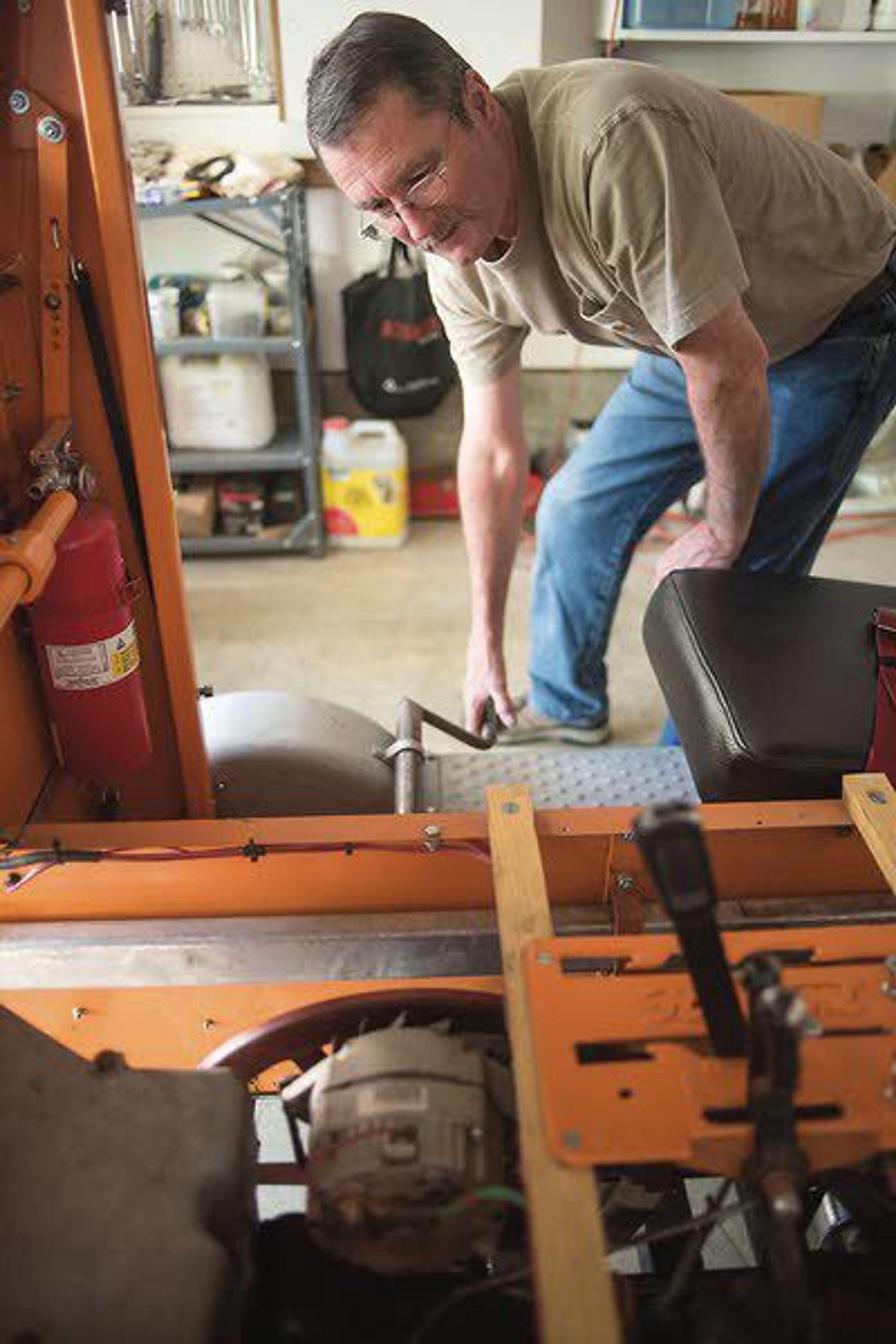 Roger Farrell shows how he crank starts his speeder's engine Wednesday in Albion. The speeder, Li'l Odge, used to be full of weeds and in pieces until Farrell fixed it up.