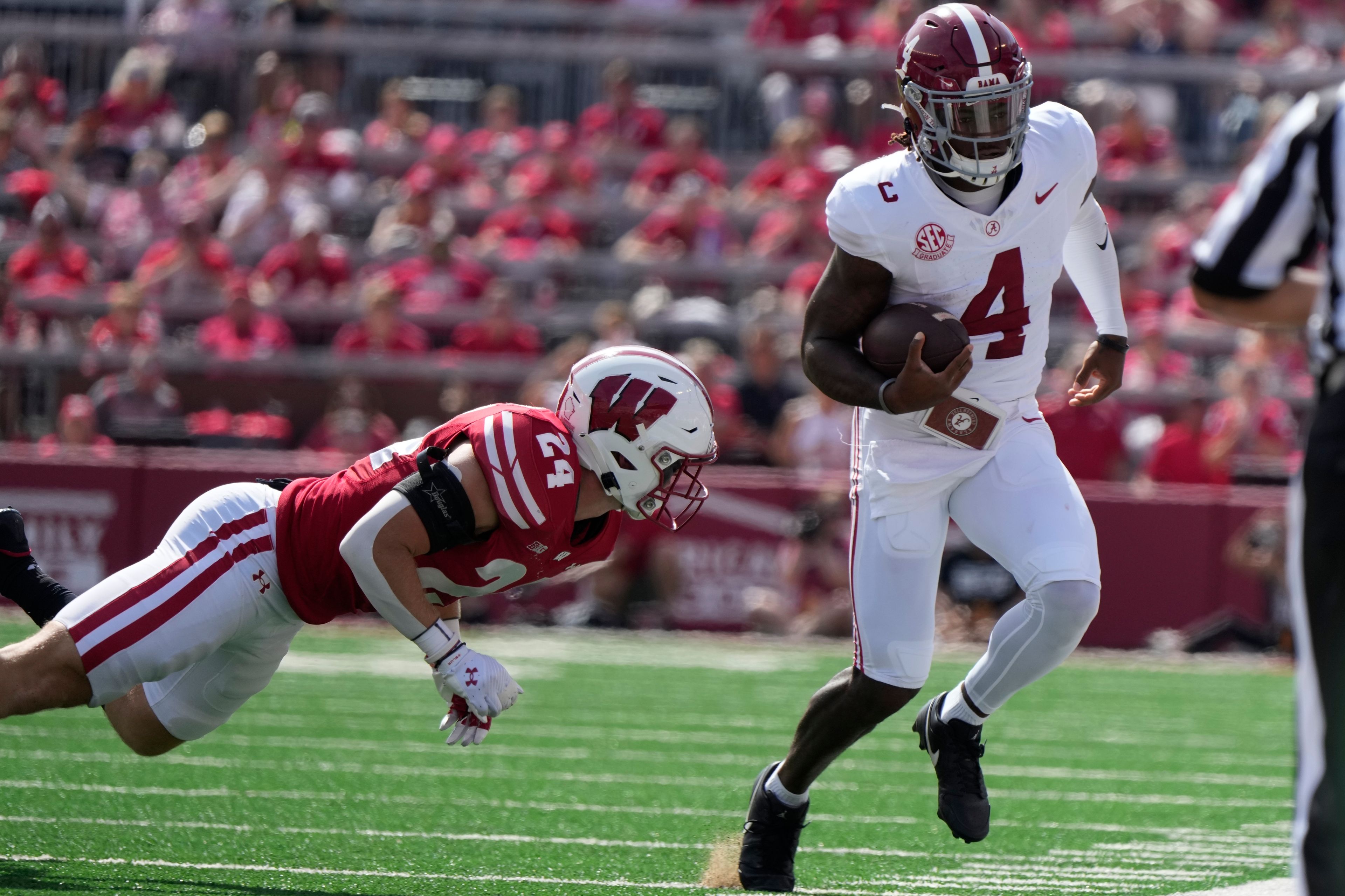 Alabama's Jalen Milroe (4) tries to get past Wisconsin's Hunter Wohler (24) during the first half of an NCAA college football game Saturday, Sept. 14, 2024, in Madison, Wis. (AP Photo/Morry Gash)