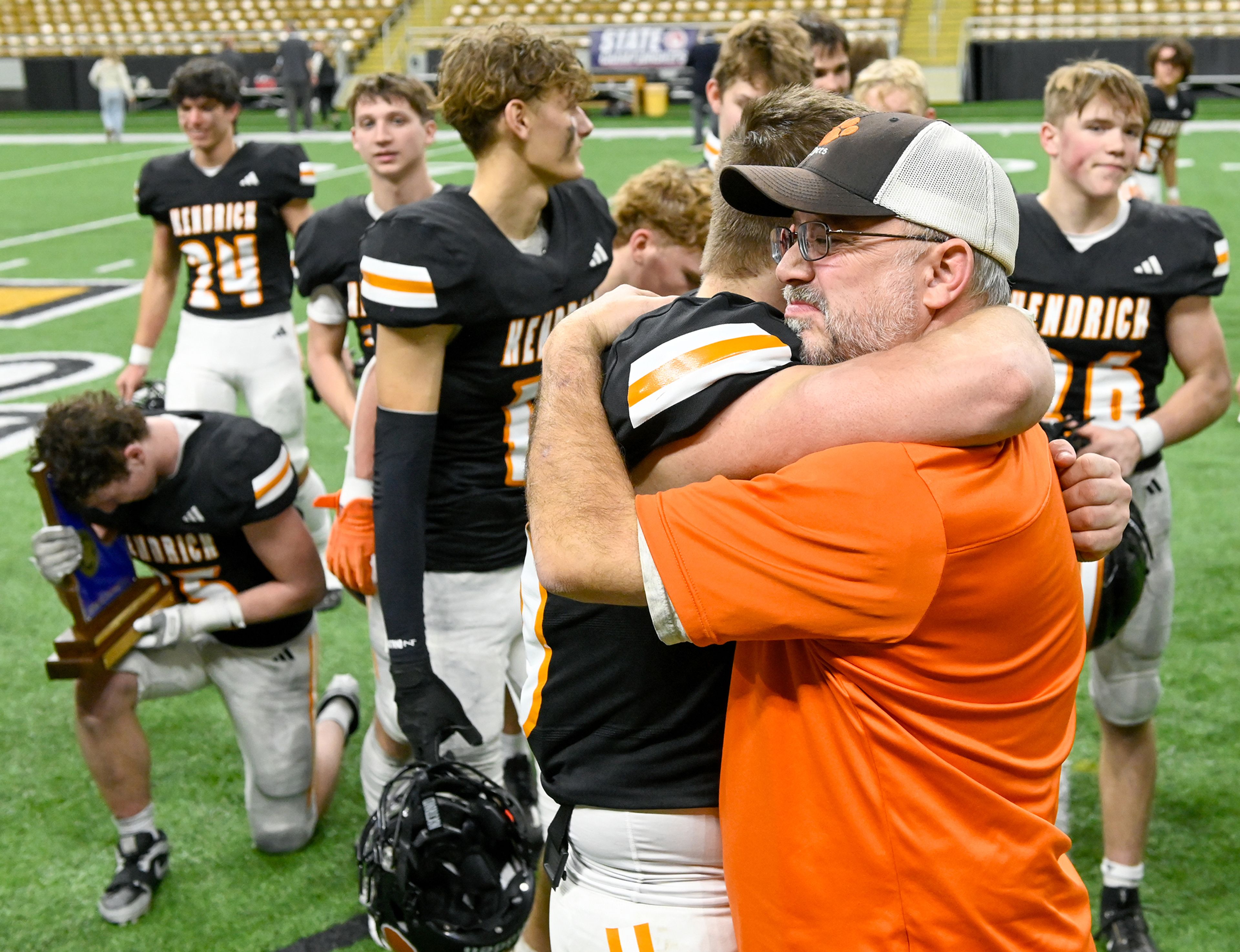 Kendrick players and coaches embrace Friday as the team celebrates their Idaho Class 2A state championship win over Butte County at the P1FCU Kibbie Dome in Moscow.