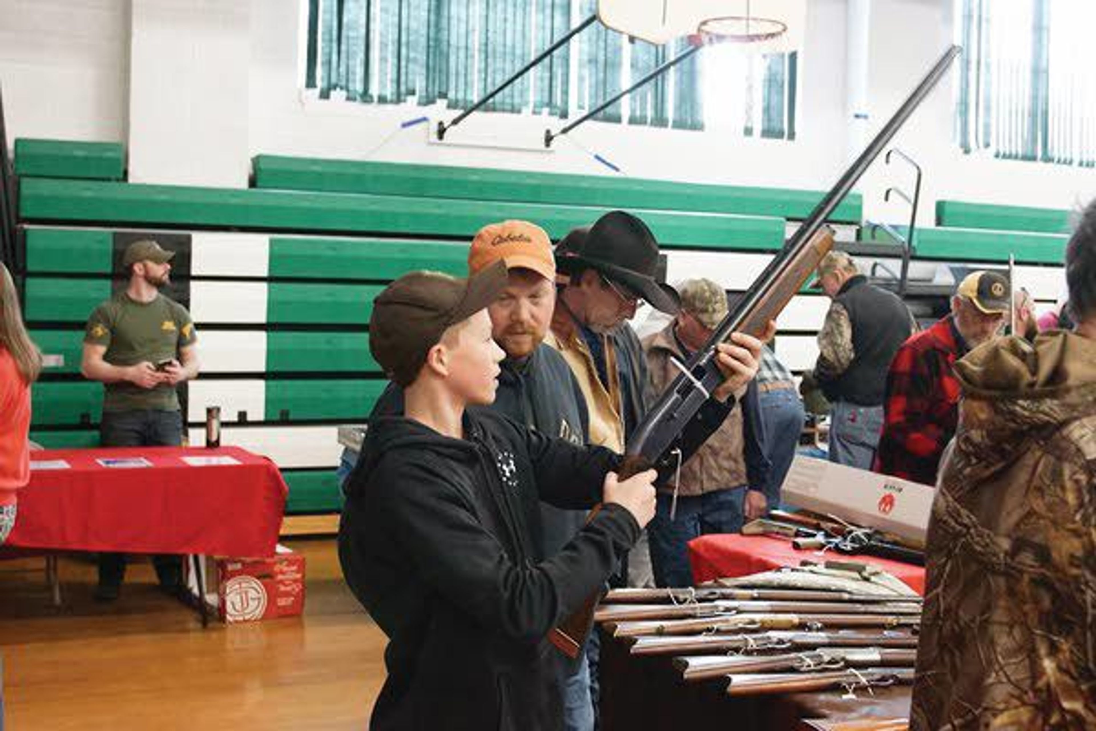 Levi Lusby looks at a shotgun with his father, Jesse, Sunday morning at the Potlatch Gun.