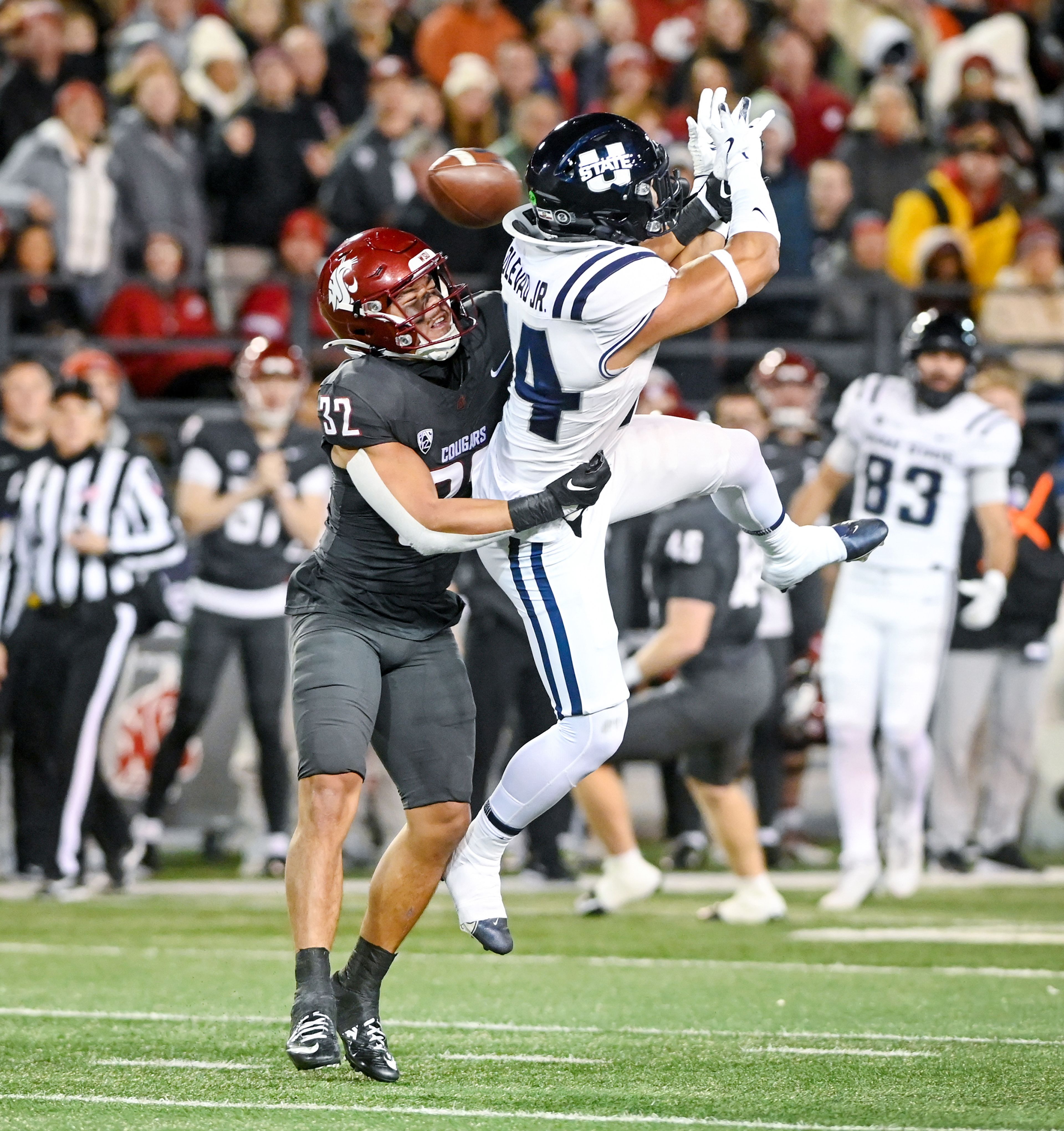 Washington State defensive back Tanner Moku (32) tackles Utah State linebacker Bronson Olevao Jr. (14), blocking Olevao from a pass, Saturday at Gesa Field in Pullman.