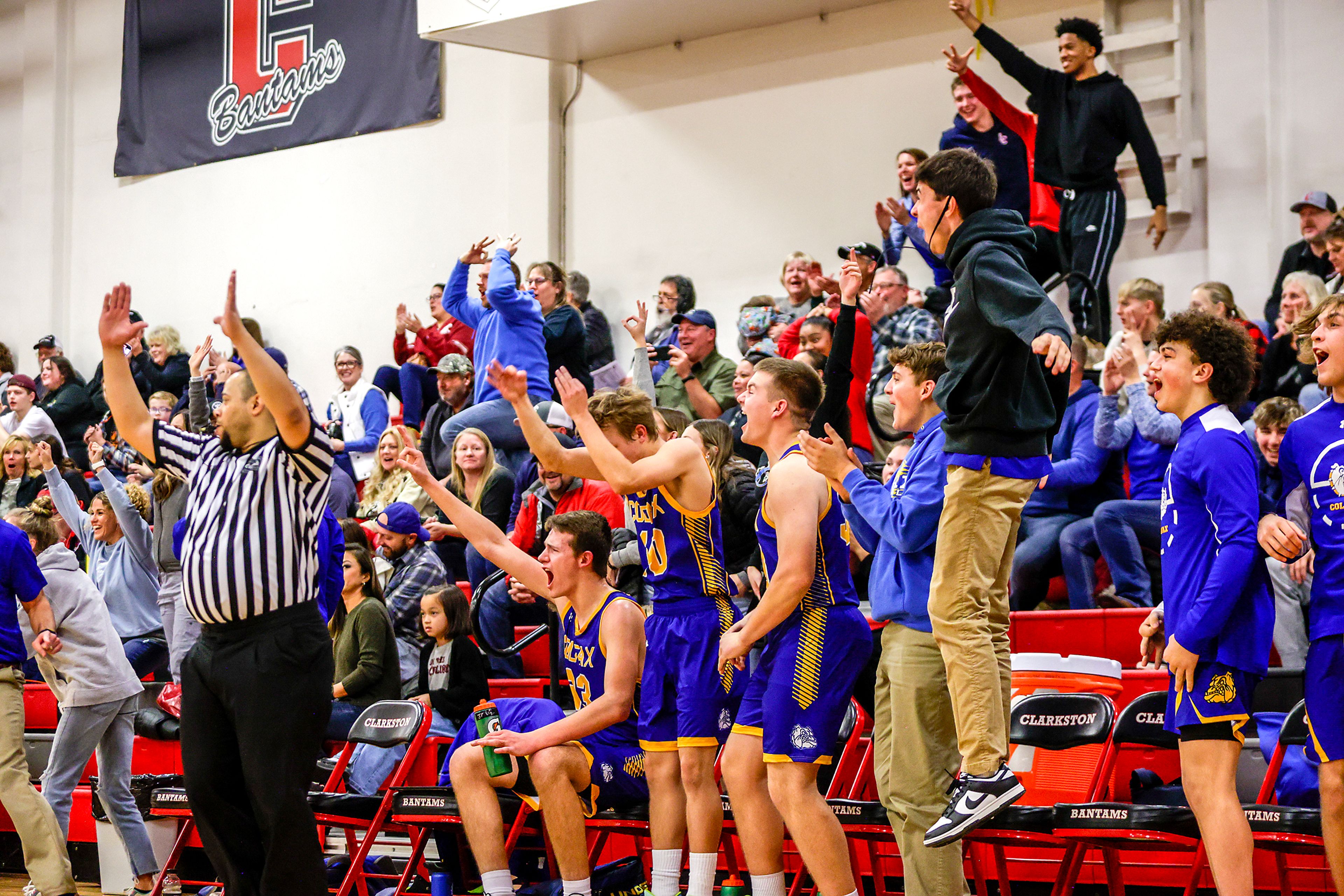 The Colfax bench and fans cheer as a basket puts them within three points of Clarkston in a quarter of a nonleague game Thursday at Clarkston.