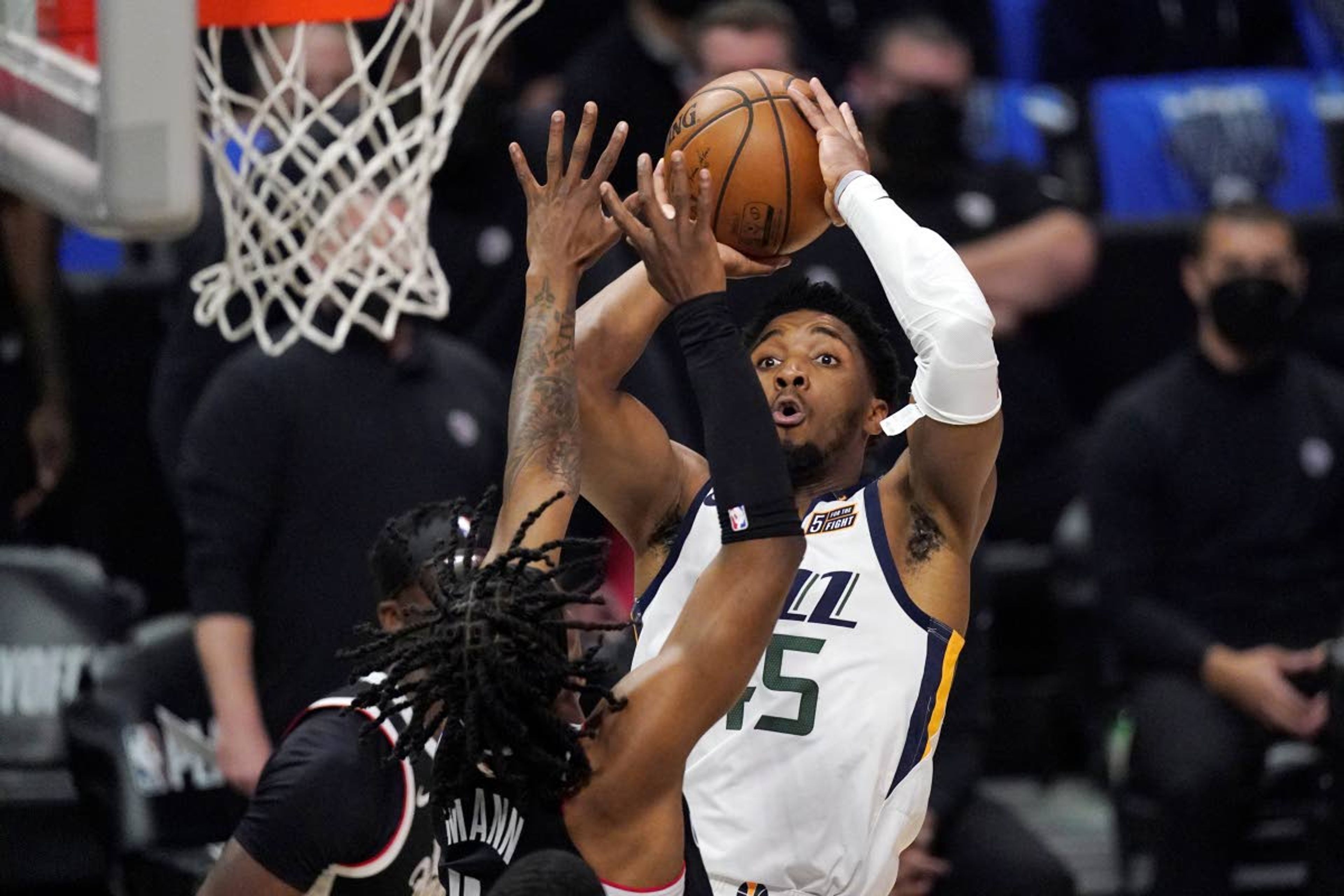 Associated PressJazz guard Donovan Mitchell, right, shoots as Clippers guard Terance Mann defends during the first half in Game 6 of a second-round NBA playoff series Friday in Los Angeles.