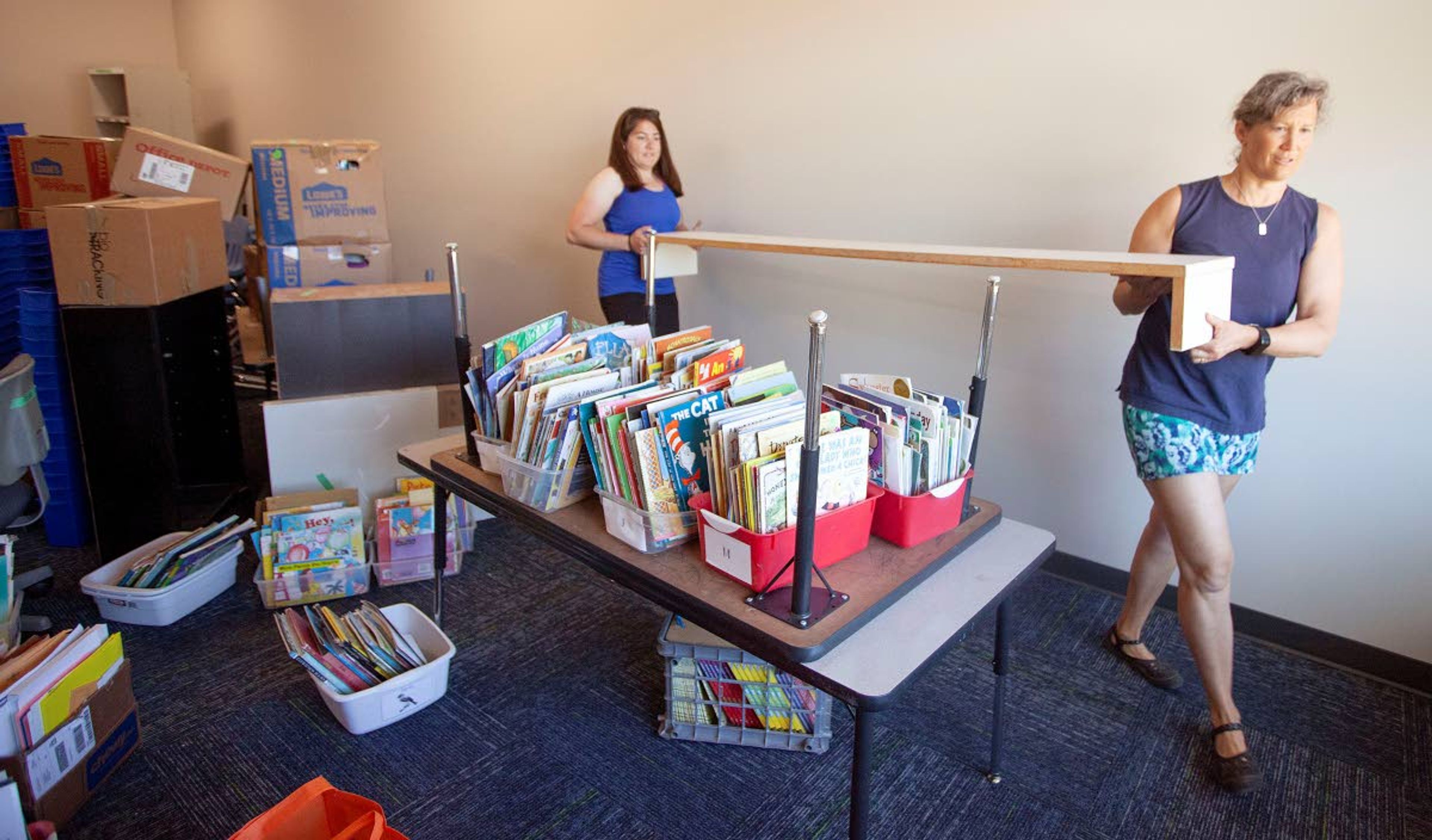 Teachers Andrika Kuhle, right, and Alissa Klemencic move a shelf while organizing Klemencic’s first-grade classroom in the new Palouse Prairie Charter School building Thursday in Moscow.