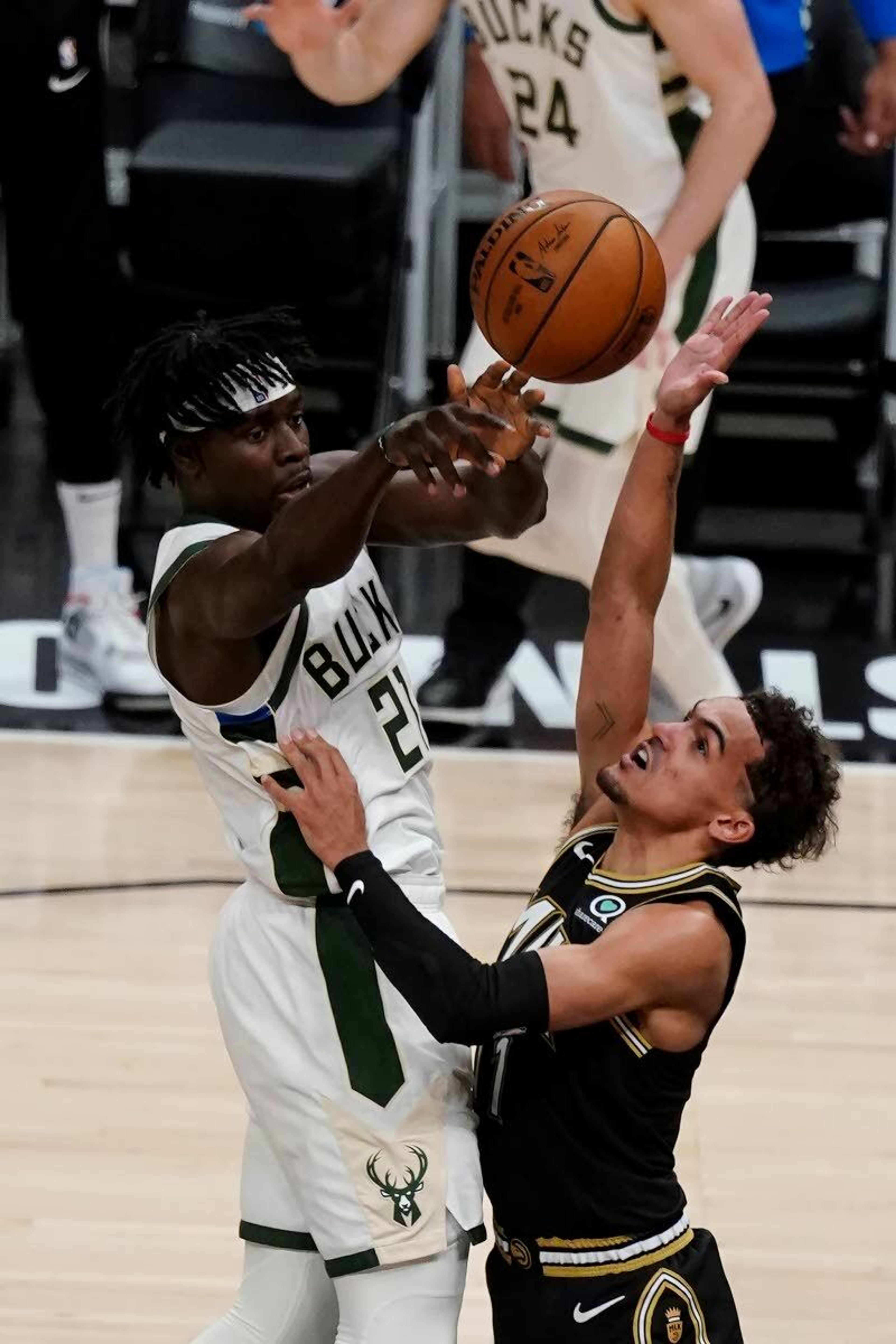 Milwaukee Bucks guard Jrue Holiday (21) passes around Atlanta Hawks guard Trae Young (11) during the second half in Game 6 of the Eastern Conference finals in the NBA basketball playoffs Saturday, July 3, 2021, in Atlanta. (AP Photo/John Bazemore)