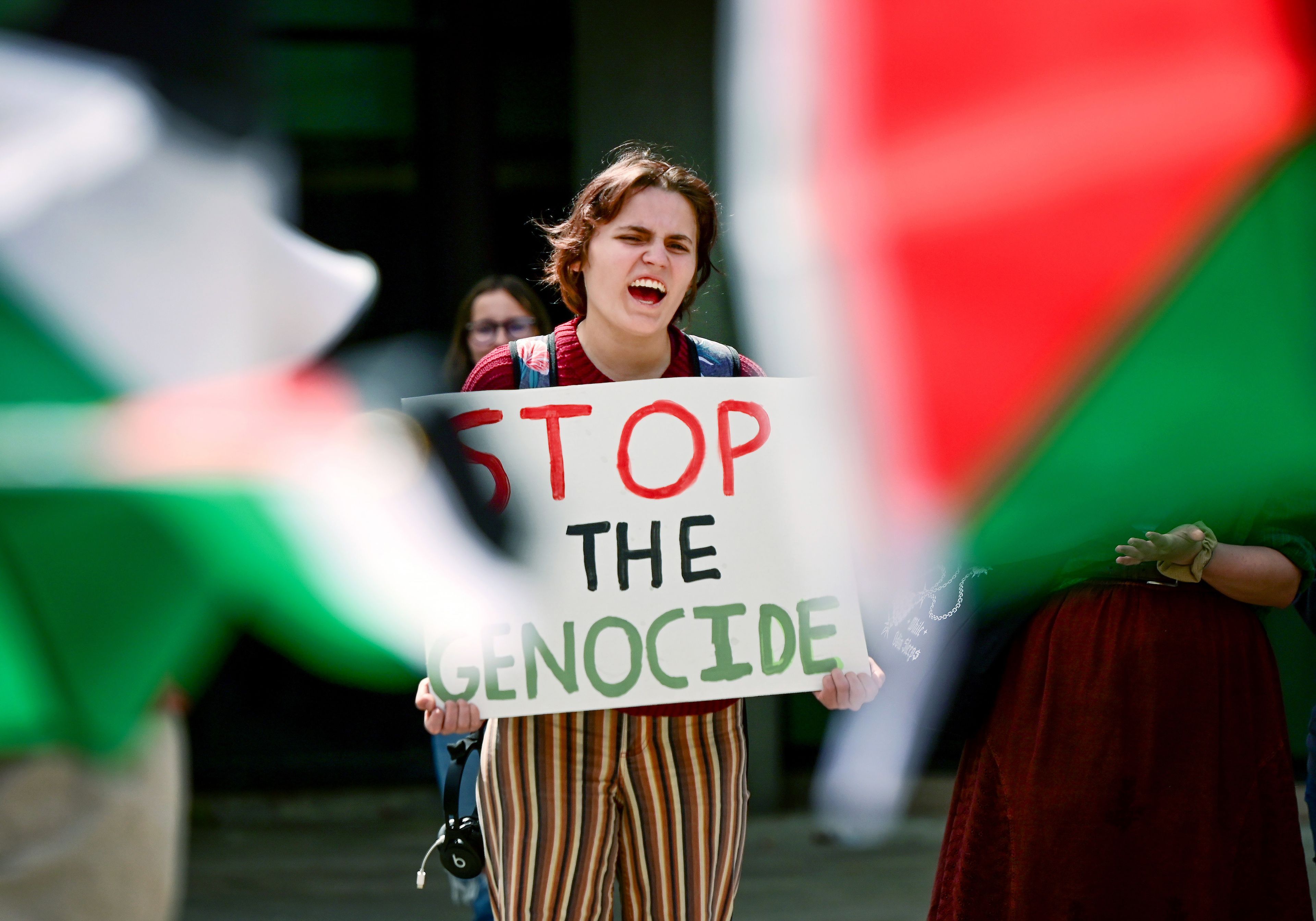 Mary Wren, a third-year University of Idaho student, is framed by Palestinian flags while shouting in agreement with a speaker at the Palestine Week of Action demonstration on campus in Moscow on Thursday.