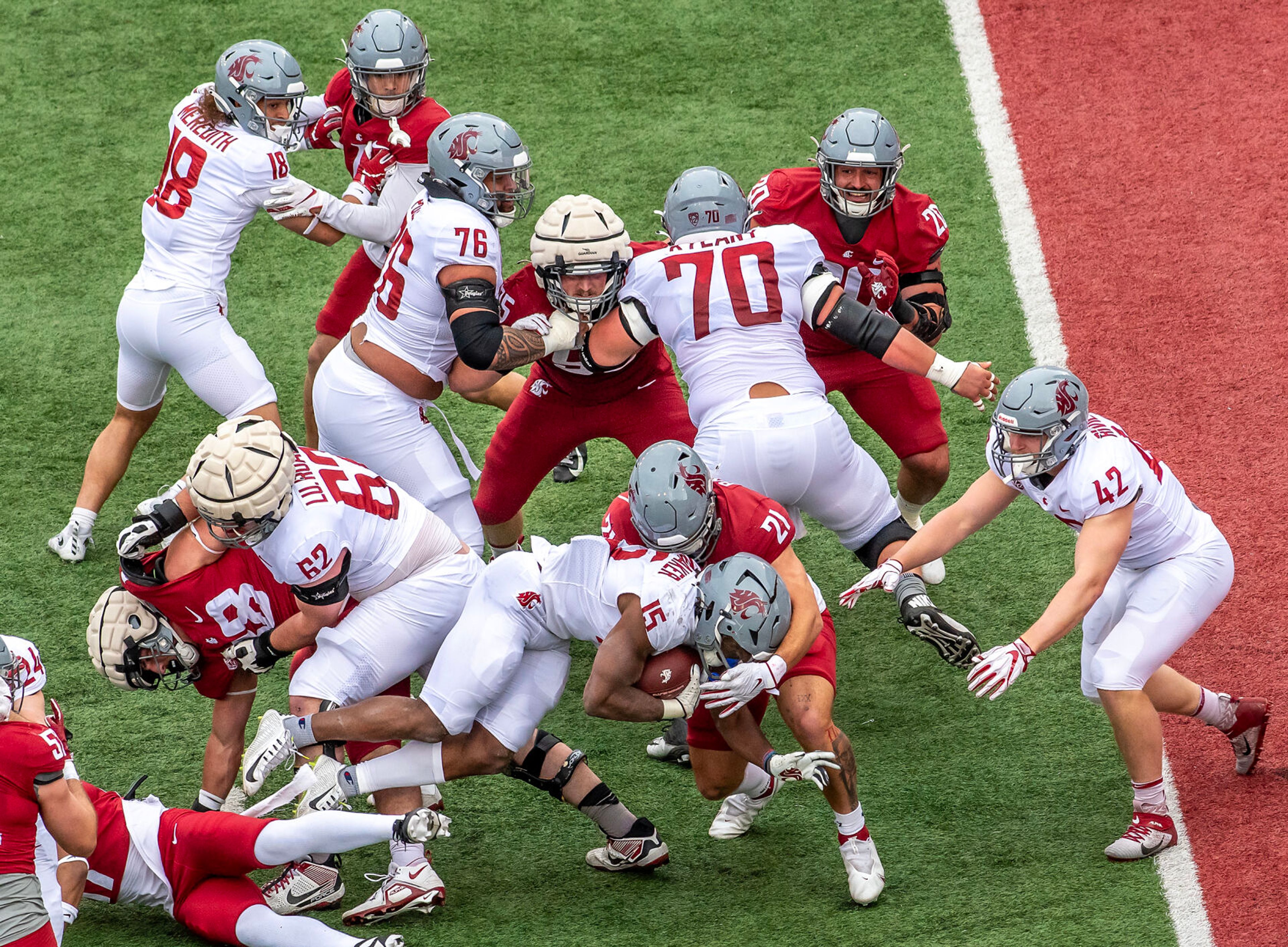 Crimson running back Djouvensky Schlenbaker holds onto the ball against Gray in a quarter of the Crimson and Gray Game at Washington State University in Pullman.