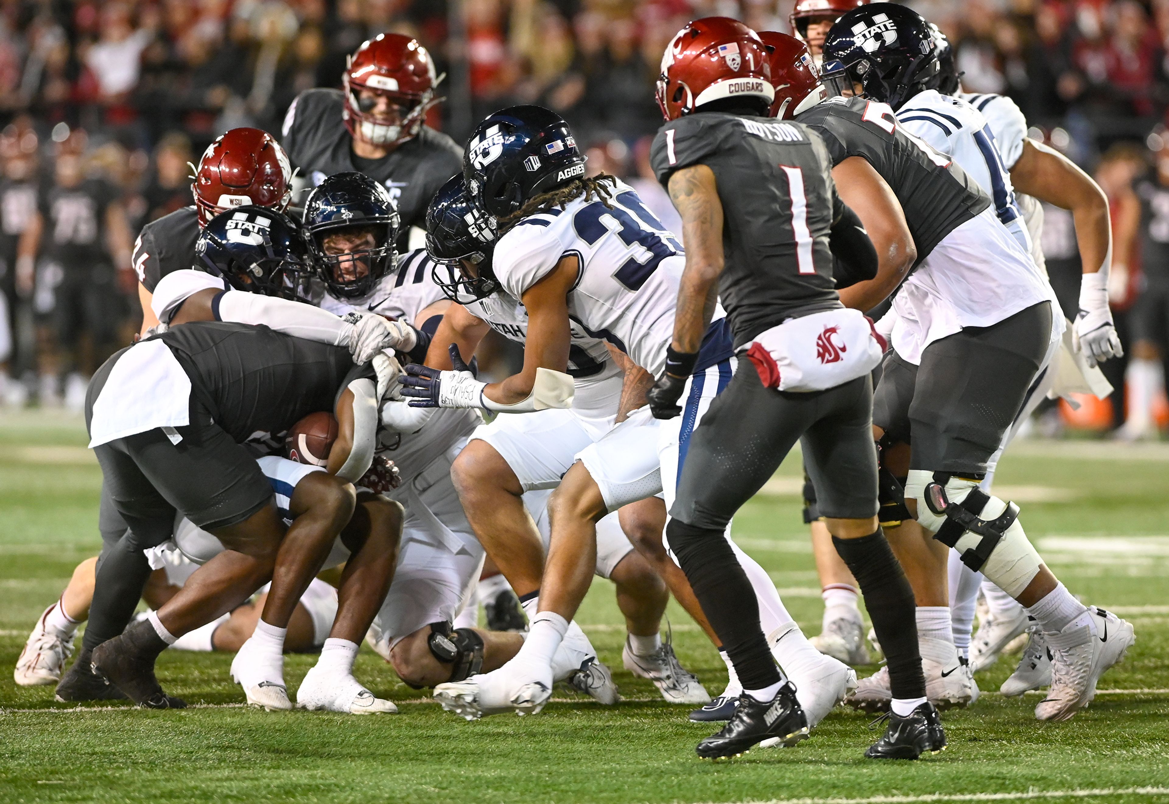 Utah State defenders tackle Washington State running back Wayshawn Parker (21) Saturday at Gesa Field in Pullman.