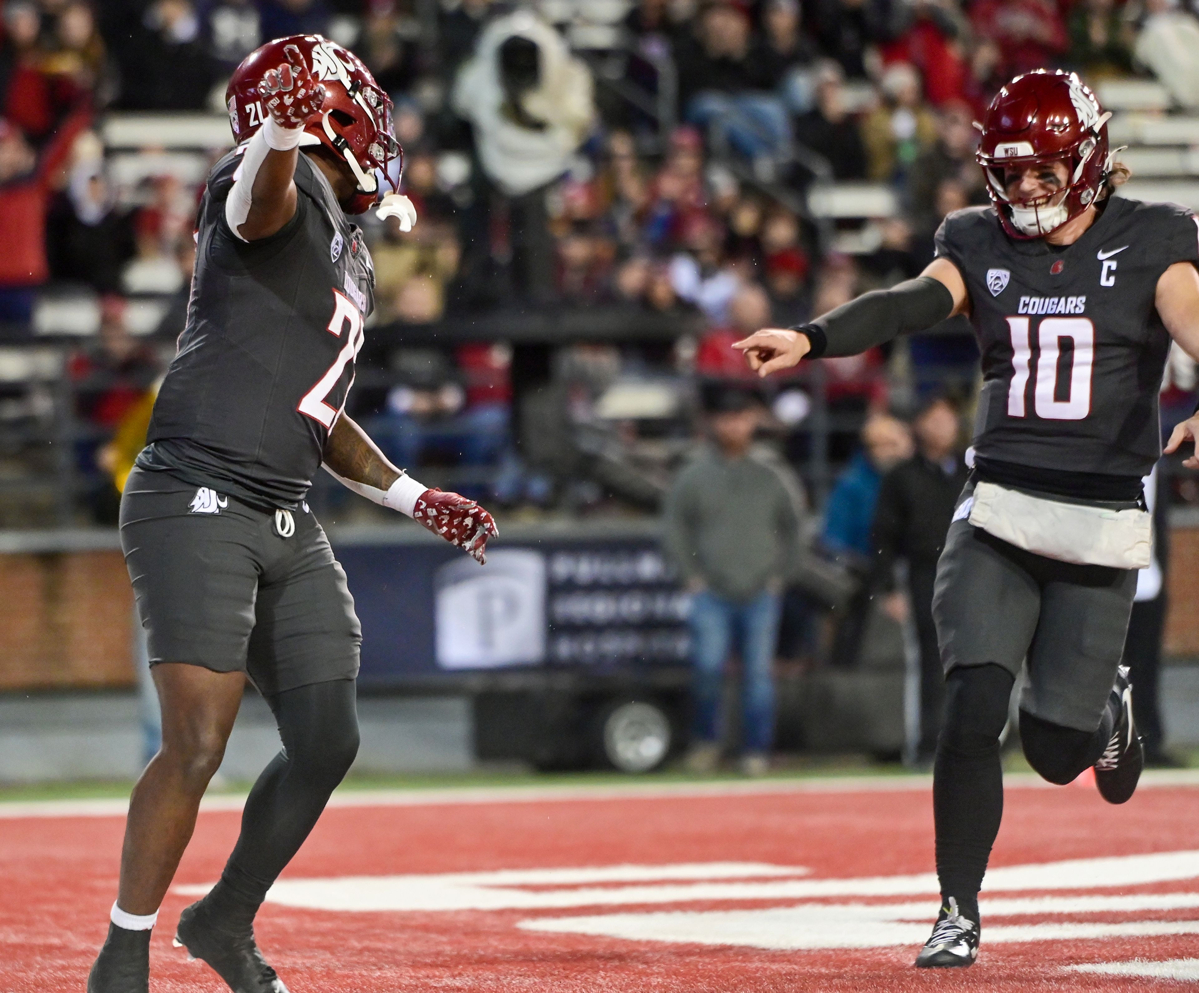 Washington State running back Wayshawn Parker (21) and Washington State quarterback John Mateer (10) celebrate Parker’s touchdown against Utah State Saturday at Gesa Field in Pullman.