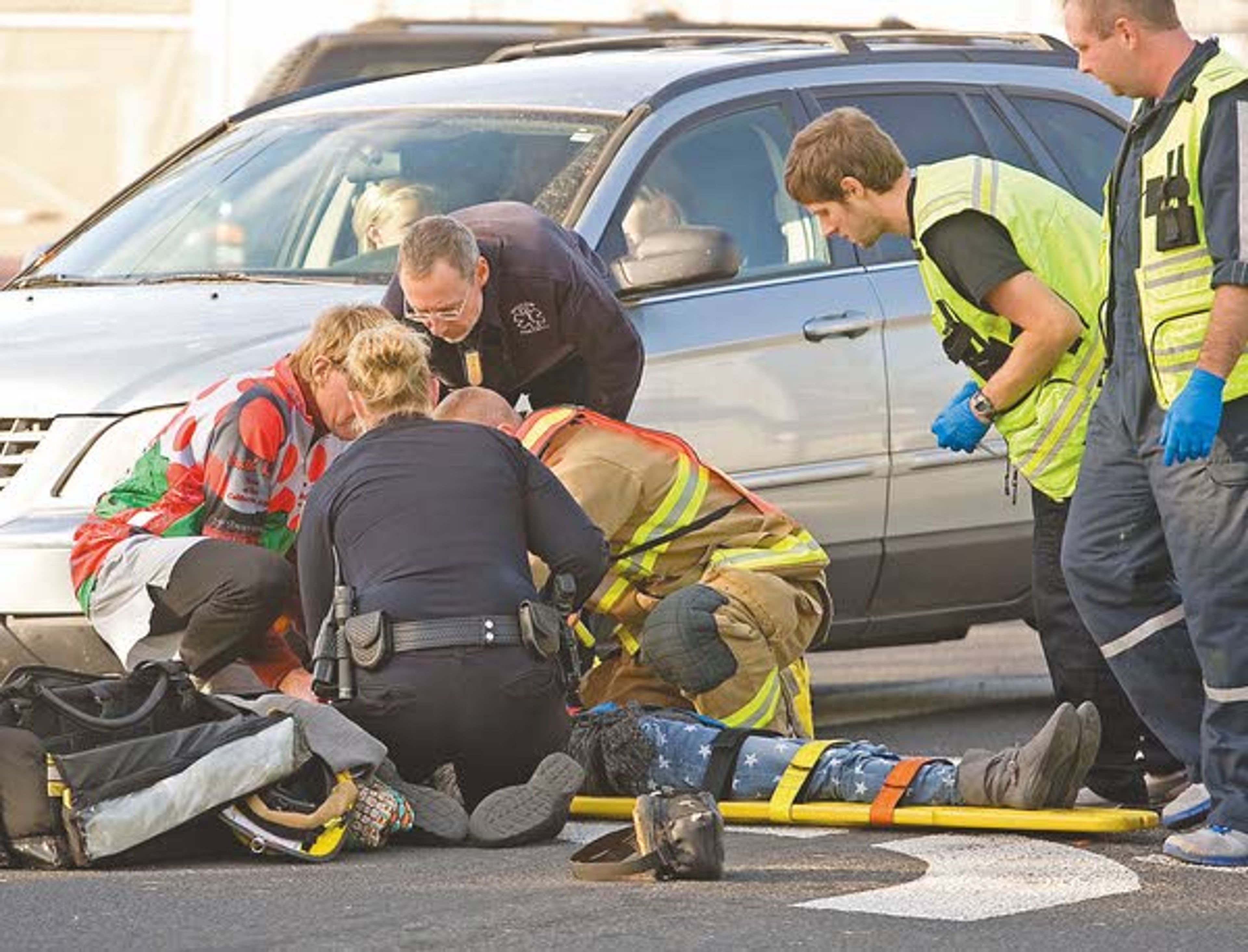 Emergency Medical Technicians and a police officer aid a Moscow Middle School student Monday after she was hit by a car at Mountain View Road and D Street in Moscow.