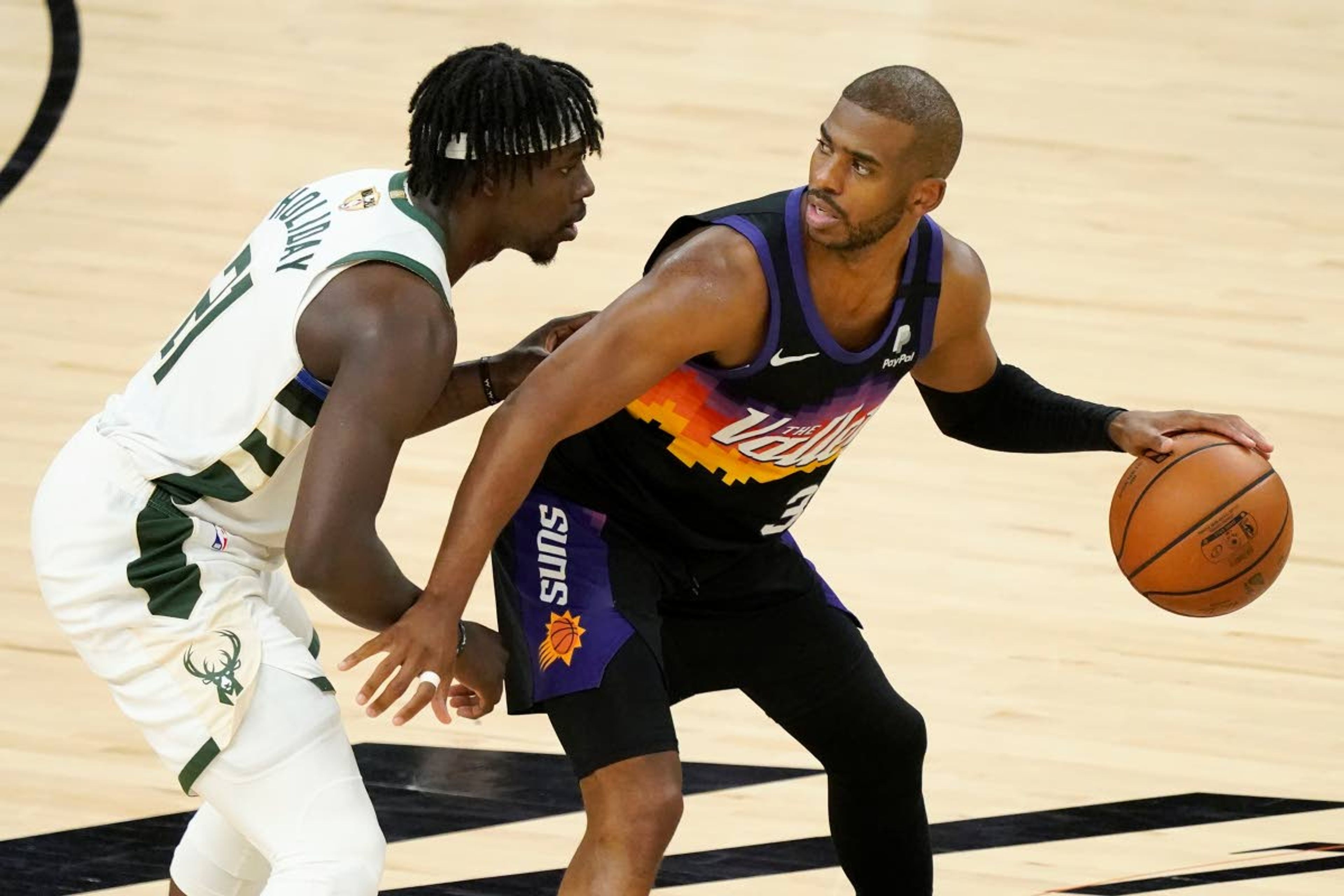 Phoenix Suns guard Chris Paul, right, is defended by Milwaukee Bucks guard Jrue Holiday during the second half of Game 2 of basketball's NBA Finals, Thursday, July 8, 2021, in Phoenix. (AP Photo/Matt York)