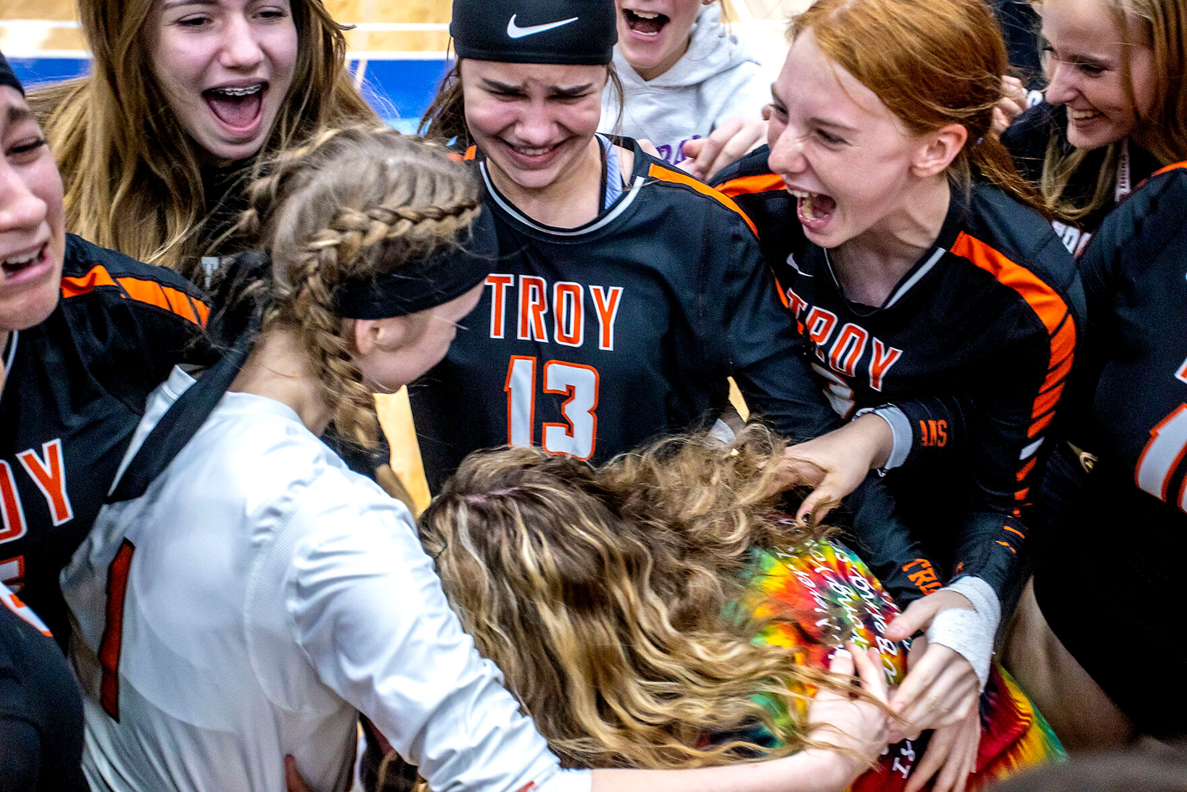 Troy surround their coach s they celebrate their victory over Grace at the Lewis-Clark State College Athletic Center on Saturday. Troy defeated Grace in three sets to become the 1A DI state champions.