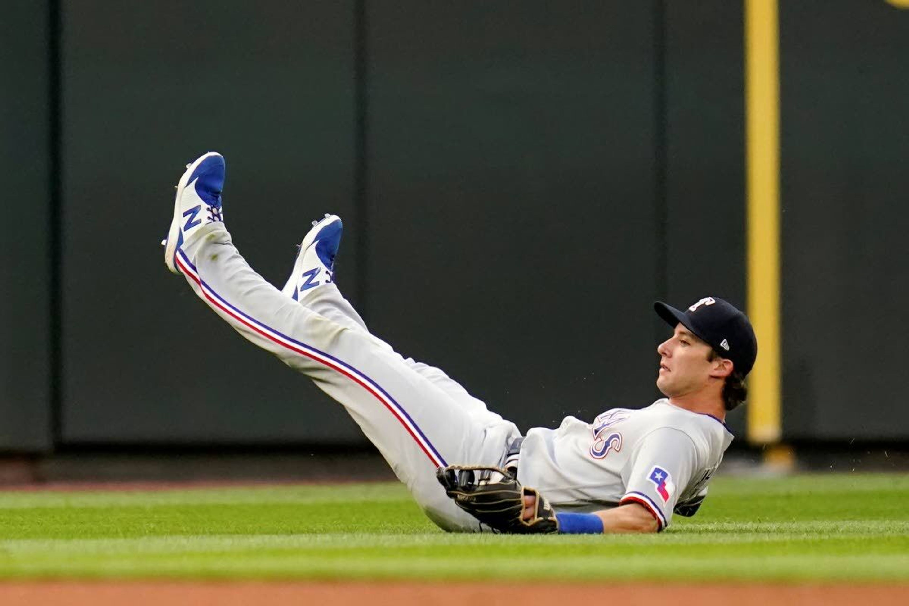 Texas Rangers left fielder Eli White skids across the turf after catching a fly ball from Seattle Mariners' Jake Fraley during the third inning of a baseball game Saturday, July 3, 2021, in Seattle. (AP Photo/Elaine Thompson)