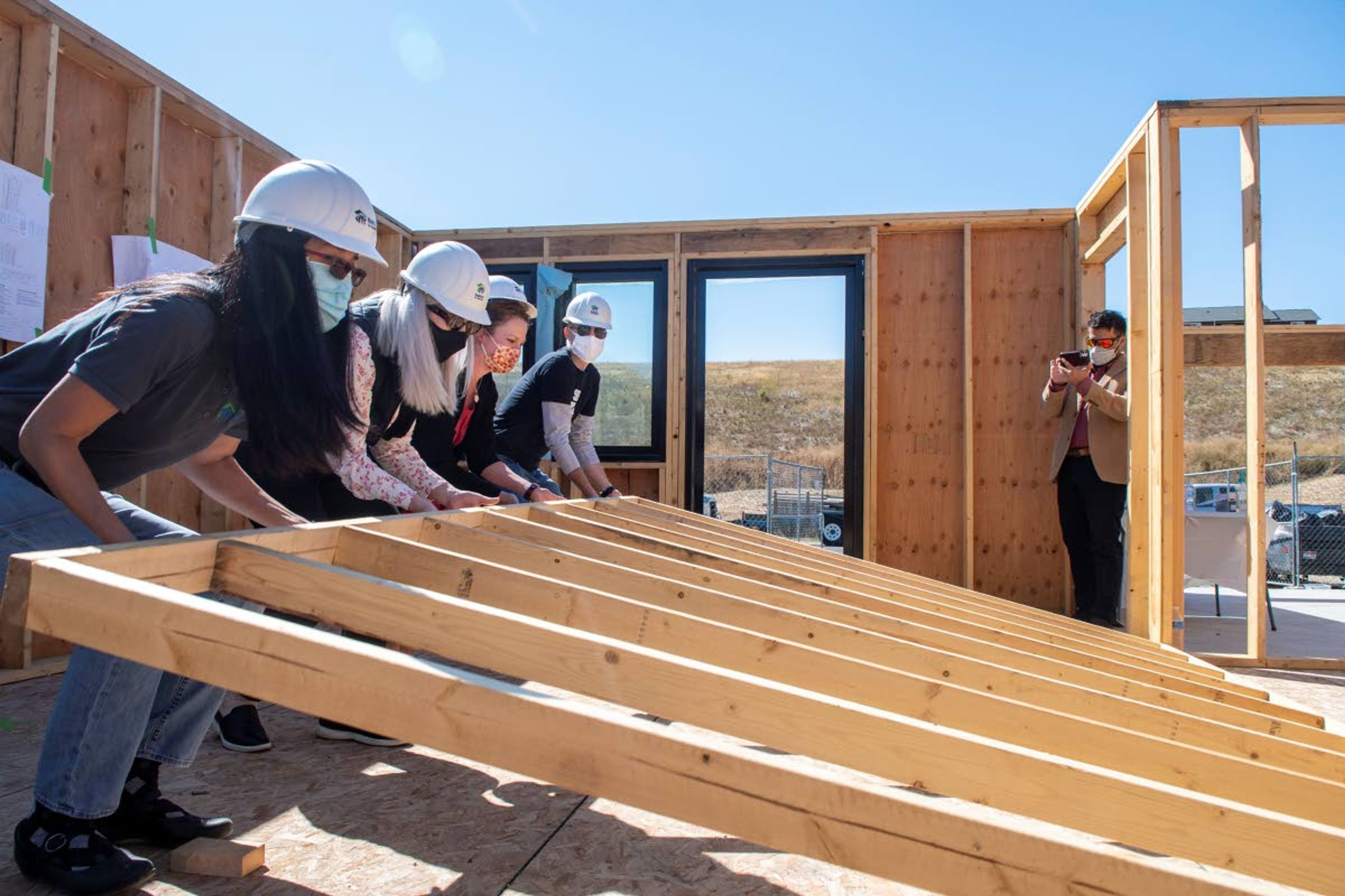 Zach Wilkinson/Daily NewsPalouse Habitat for Humanity and Washington State University representatives Cathy Blood, from left, Mary Rezac, Jessica Perone and Ryan Smith raise the final wall of an energy efficient house during a celebration in Uniontown on Thursday afternoon. “I think the experience is that the celebration is a testament to how multi-organizations can work together and really impact the community and make a positive difference with affordable housing,” Blood said.