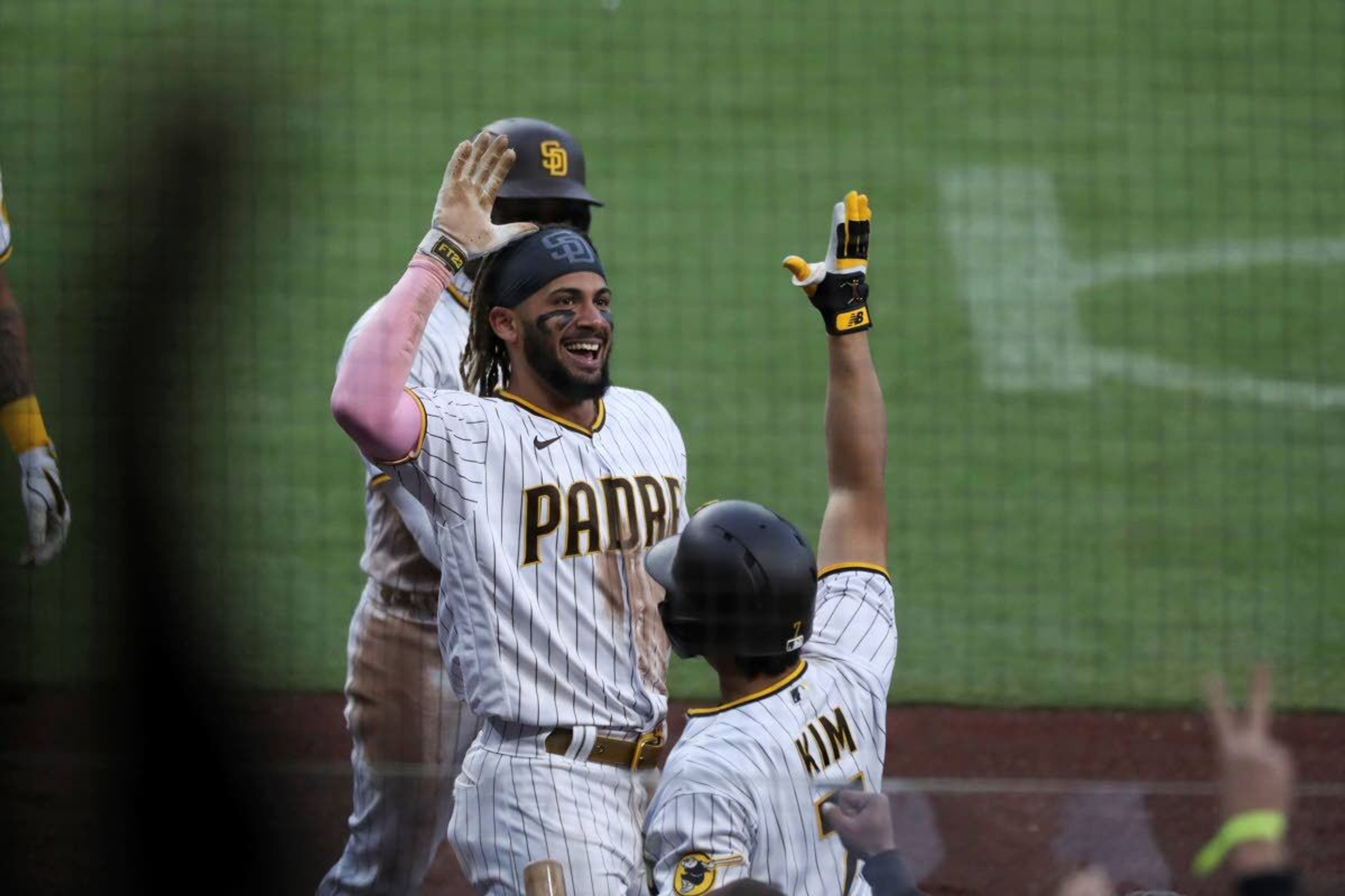 San Diego Padres' Fernando Tatis Jr., left, is congratulated by Ha-Seong Kim after scoring during the fifth inning of a baseball game against the Seattle Mariners on Saturday, May 22, 2021, in San Diego. (AP Photo/Derrick Tuskan)