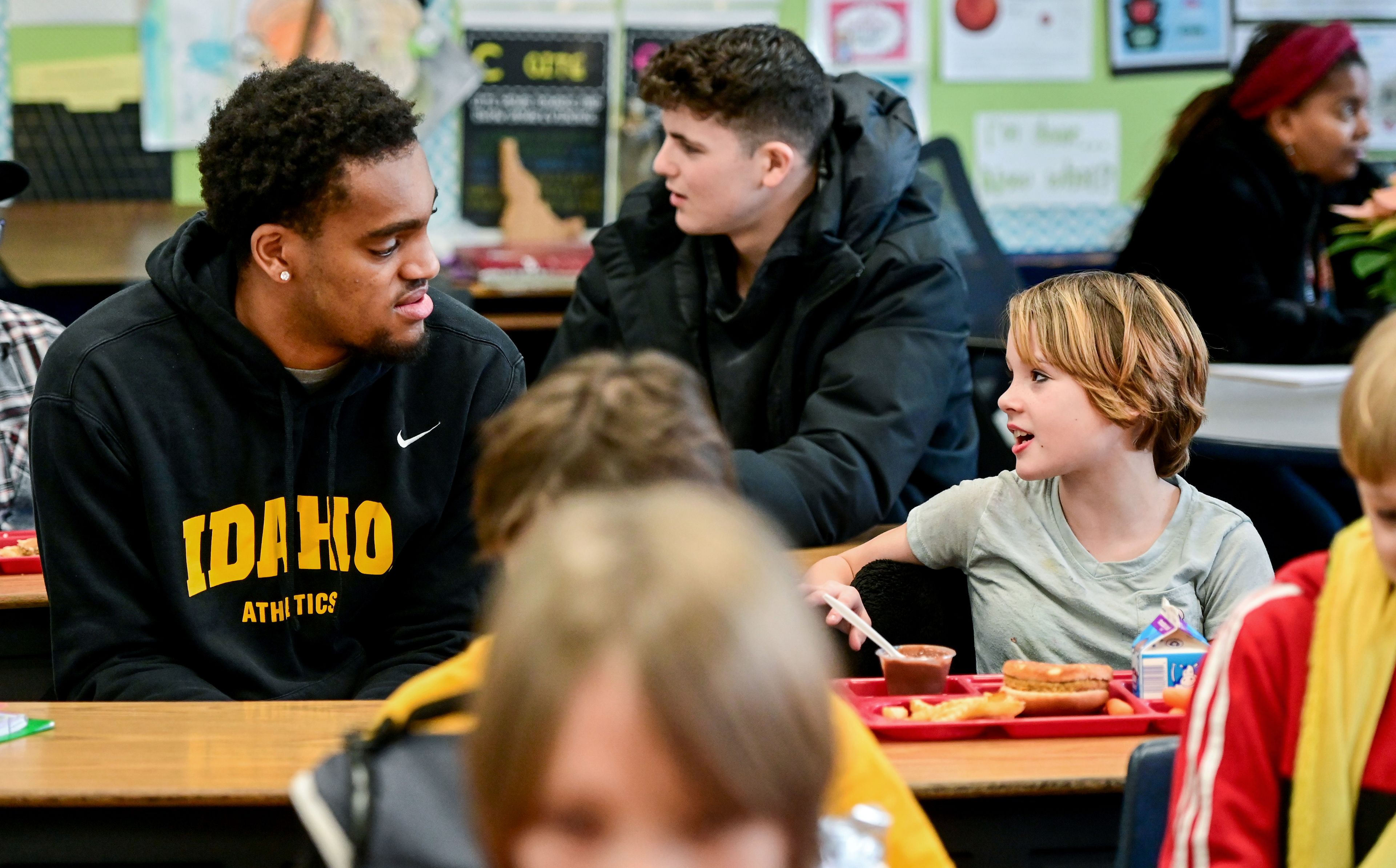 Idaho Vandal Terren Frank talks with fifth grader Sam M. during lunch at John Russell Elementary School in Moscow on Monday. The Vandals visit with students a few times each month during lunch and recess as mentors.