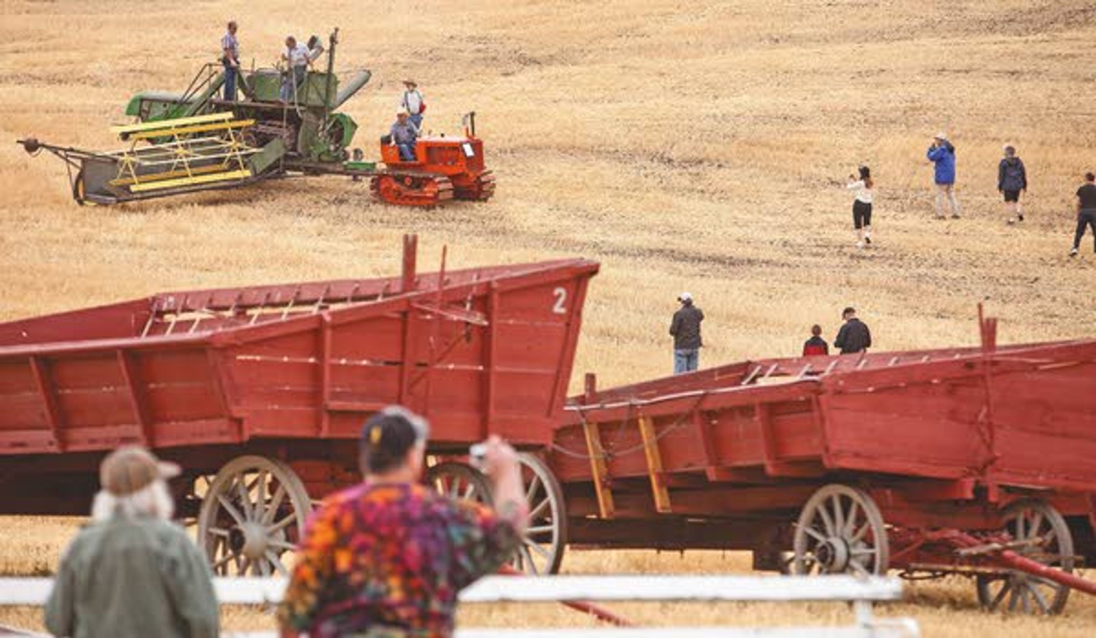 Photographers at right line up shots of a dozer towing a combine during the rained-out annual Palouse Empire Threshing Bee on Monday, Sept. 2, 2013, outside the Palouse Empire Fairgrounds in Colfax.