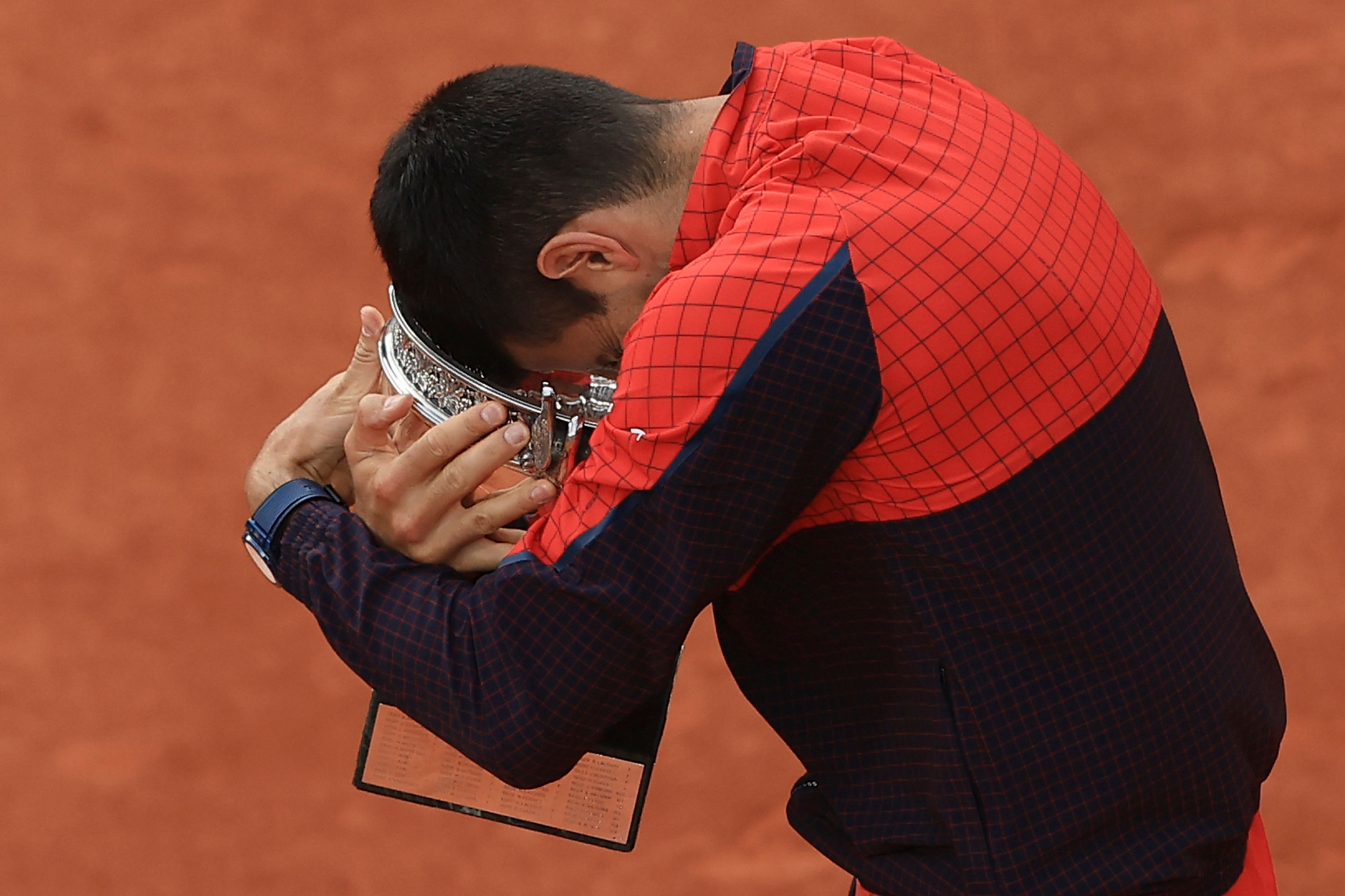 Serbia's Novak Djokovic hugs the trophy as he celebrates winning the men's singles final match of the French Open tennis tournament against Norway's Casper Ruud in three sets, 7-6, (7-1), 6-3, 7-5, at the Roland Garros stadium in Paris, Sunday, June 11, 2023. Djokovic won his record 23rd Grand Slam singles title, breaking a tie with Rafael Nadal for the most by a man. (AP Photo/Aurelien Morissard)