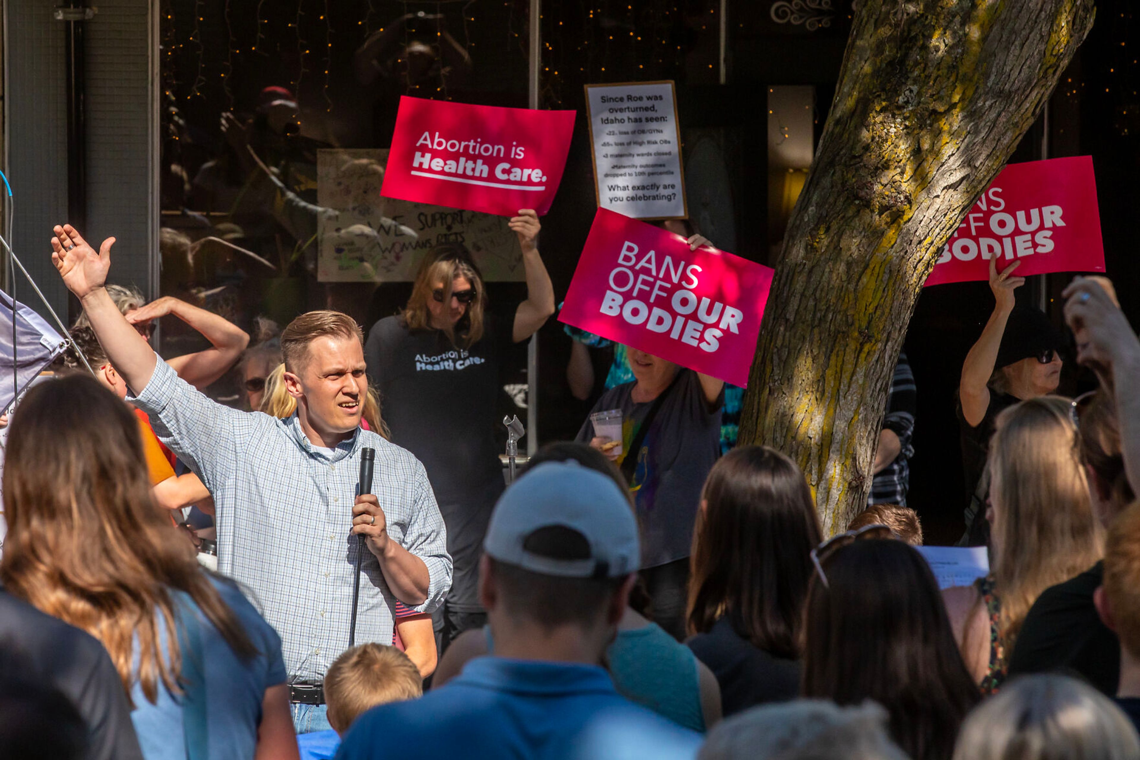 Protesters hold signs as a person speaks about the overturning of Roe v. Wade during a block party on Main Street Monday in Moscow.