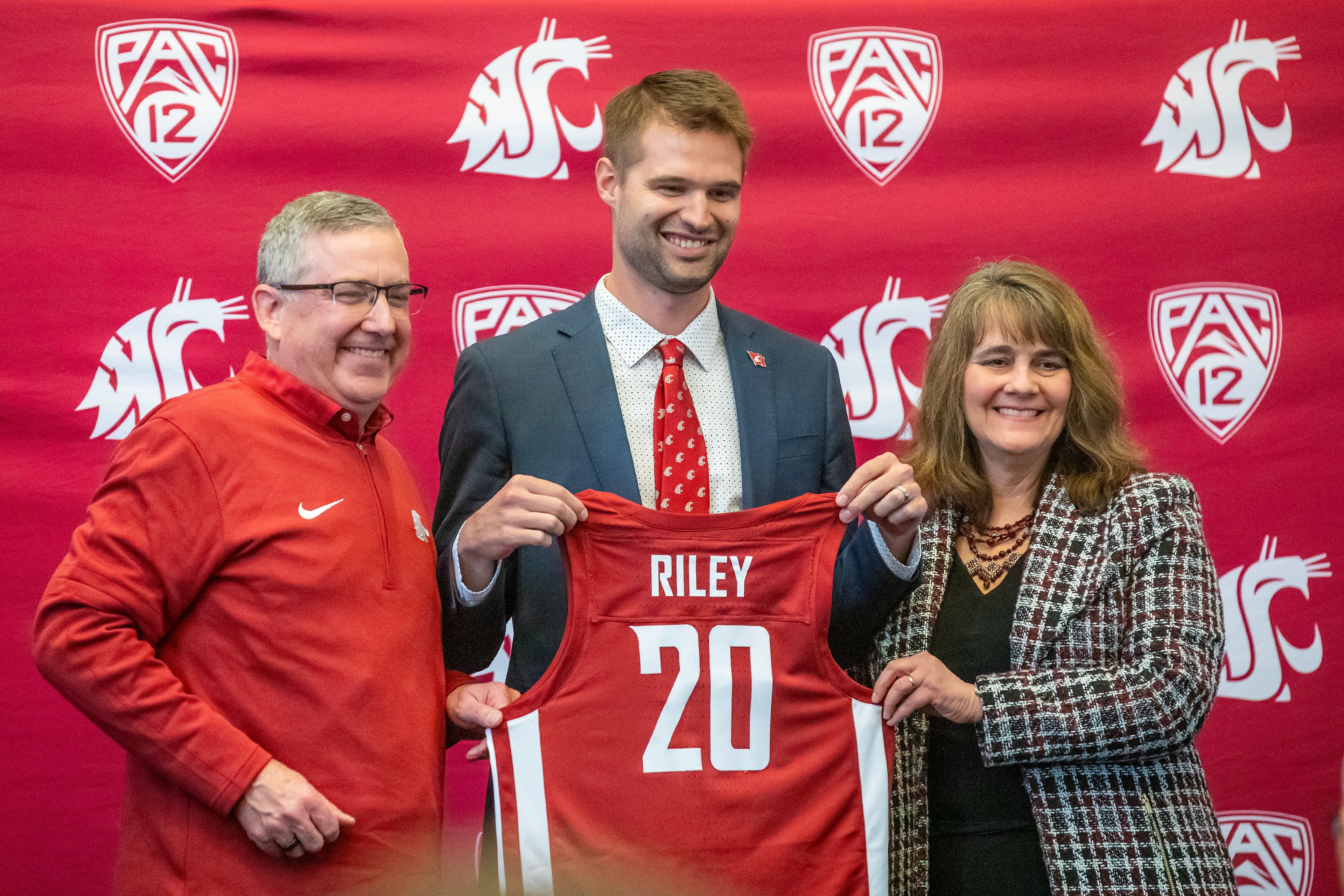 David Riley holds up a jersey next to Washington State President Kirk Schulz and athletic director Anne McCoy April 5 in Pullman. McCoy was elevated to athletic director on Tuesday.