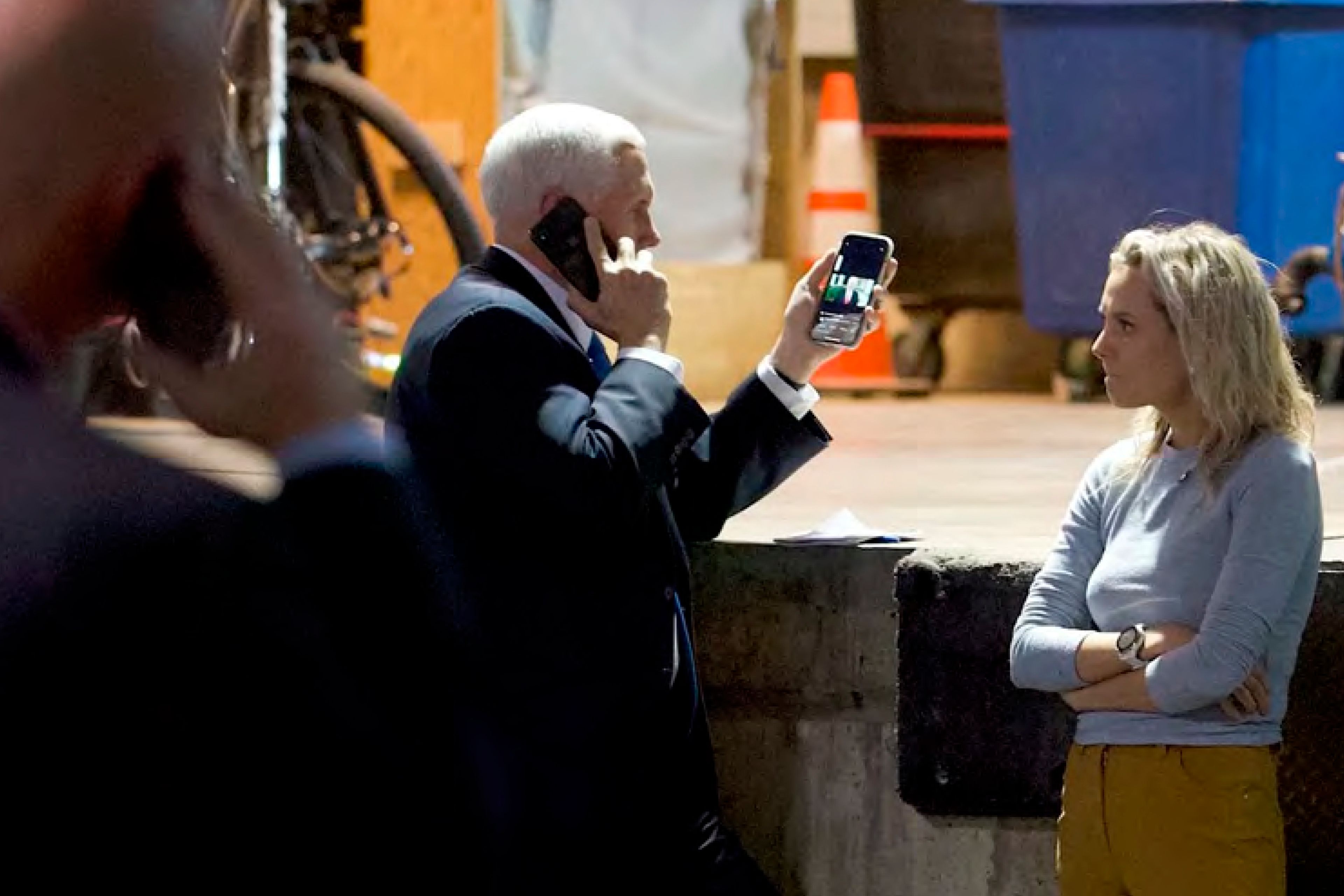 In this image released in the final report by the House select committee investigating the Jan. 6 attack on the U.S. Capitol, on Thursday, Dec. 22, 2022, Vice President Mike Pence talks on the phone from a secured loading dock at the U.S. Capitol as he looks at another phone with a recording of video statement President Donald Trump on Jan. 6, 2021. (House Select Committee via AP)