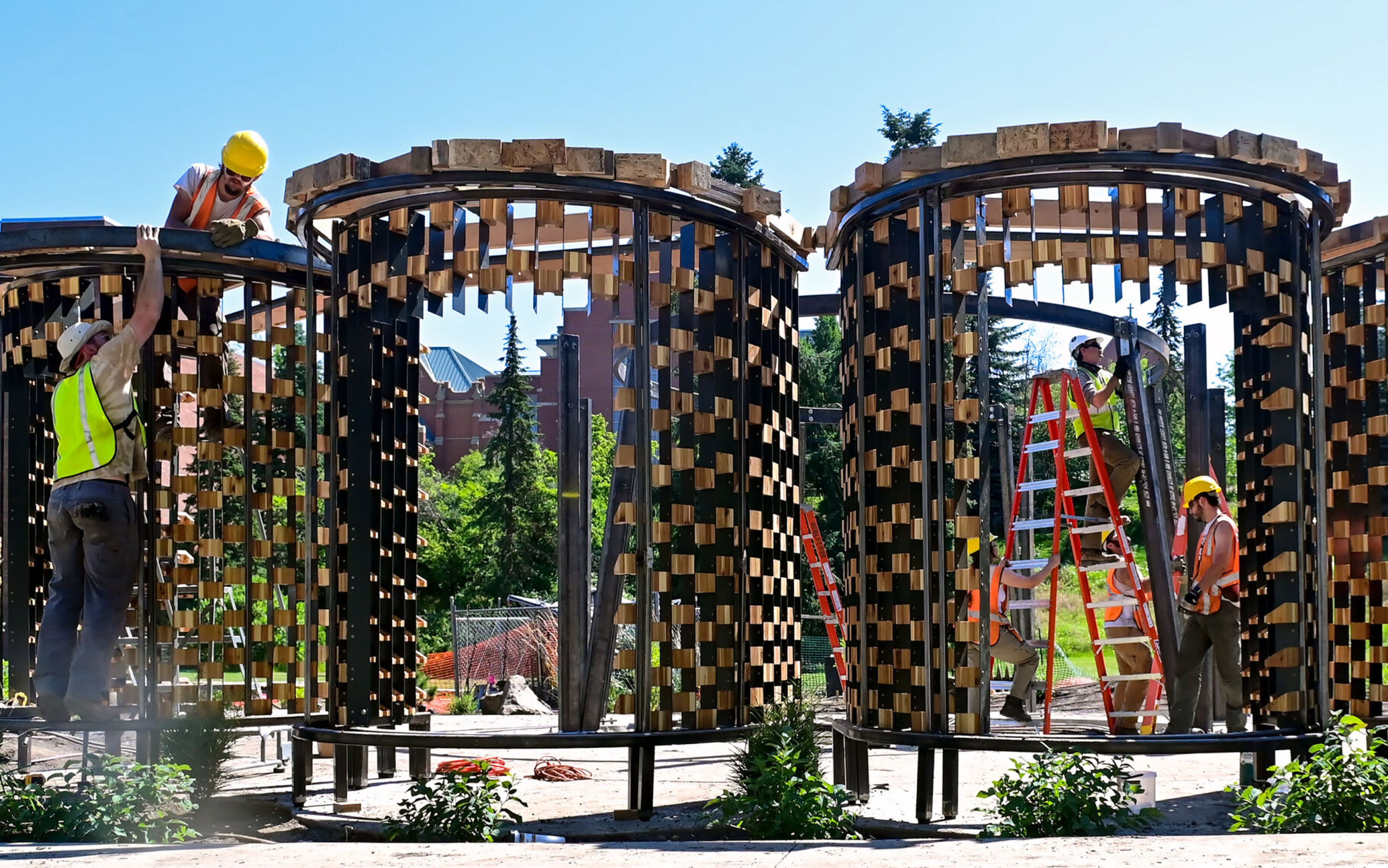 University of Idaho architecture students work to build the Vandal Healing Garden and Memorial in Moscow on Tuesday. Sitting areas, front, and a central memorial site, back right, are visible as the students build out the structures.