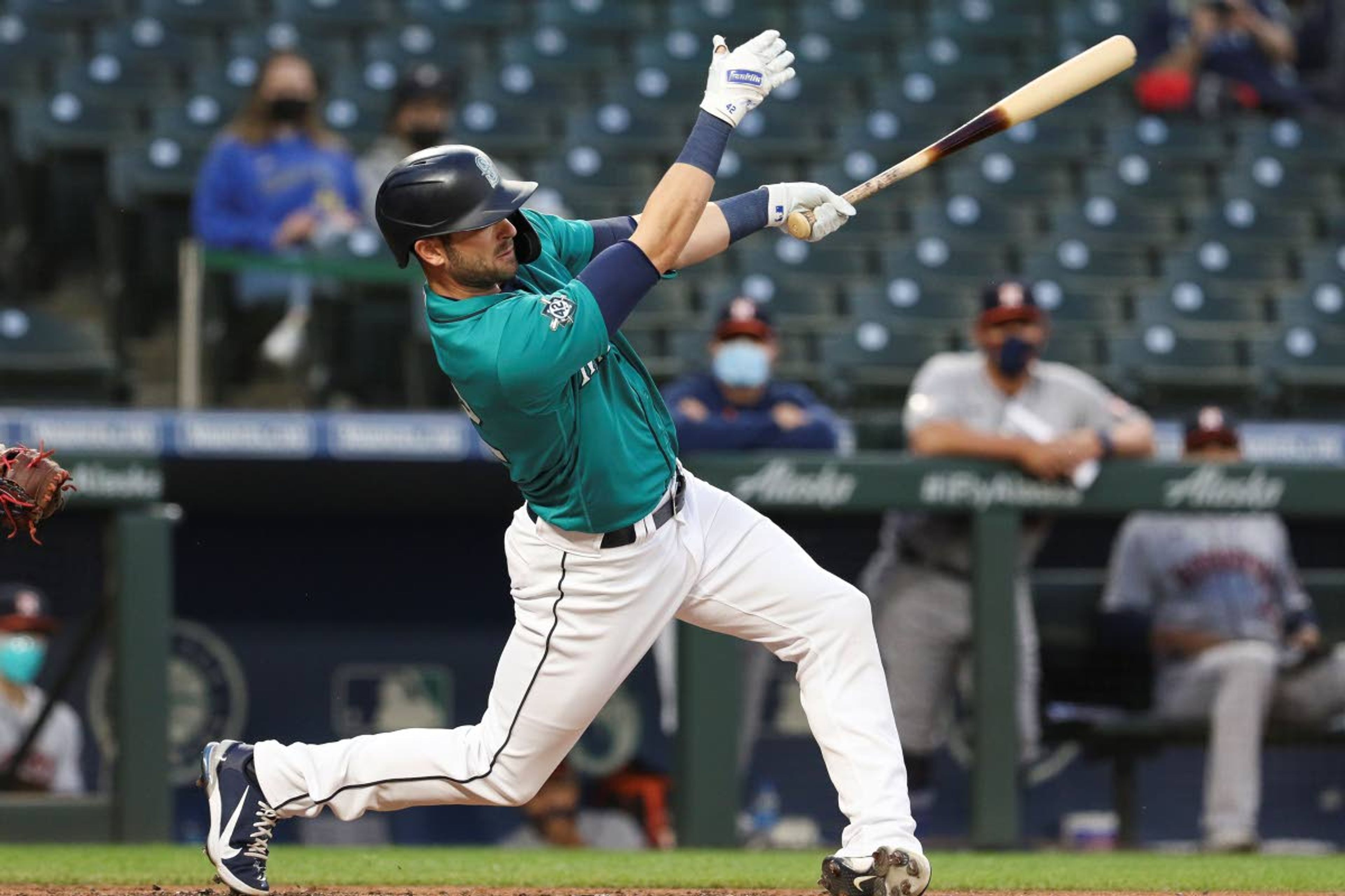 Seattle Mariners' Mitch Haniger singles on a line drive during the third inning of the team's baseball game against the Houston Astros on Friday, April 16, 2021, in Seattle. (AP Photo/Jason Redmond)