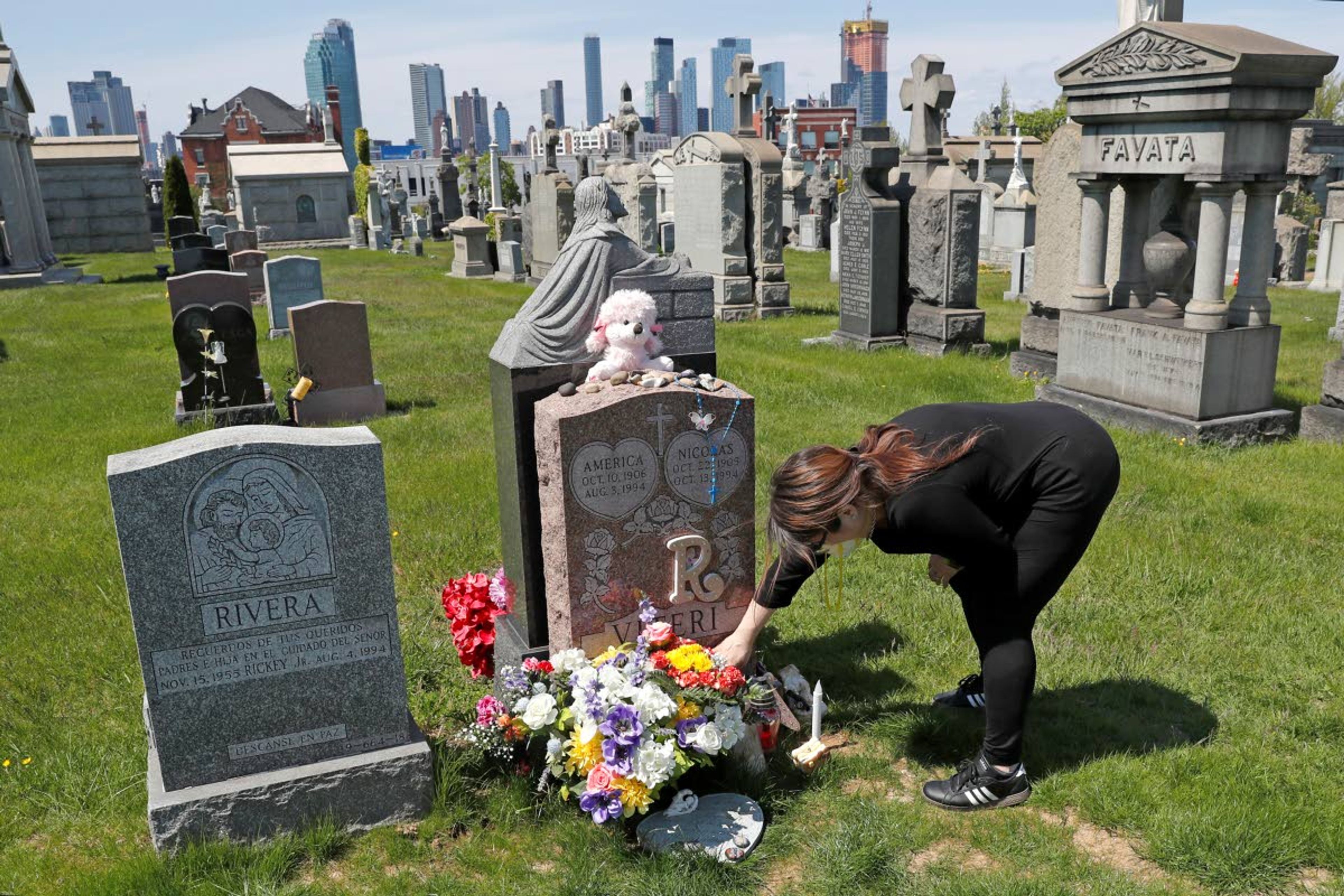 FILE - In this Sunday, May 10, 2020 file photo, Sharon Rivera adjusts flowers and other items left at the grave of her daughter, Victoria, at Calvary Cemetery in New York, on Mother’s Day. Victoria died of a drug overdose in Sept. 22, 2019, when she just 21 years old. According to a report released by the Centers for Disease Control and Prevention on Wednesday, July 14, 2021, drug overdose deaths soared to a record 93,000 last year in the midst of the COVID-19 pandemic. (AP Photo/Kathy Willens, File)