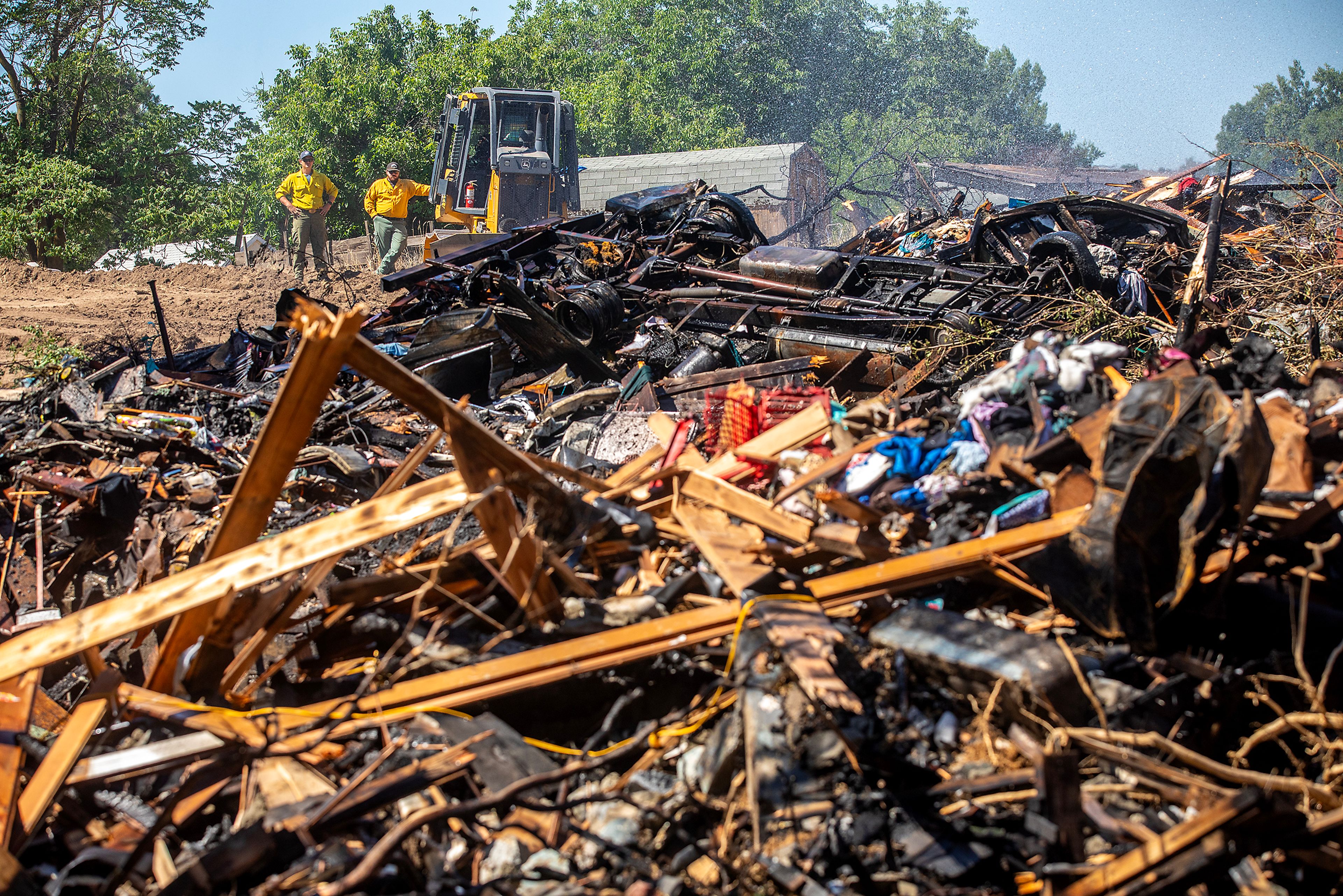 Firefighters look over the debris left after a structure fire caused by a firework in Clarkston.