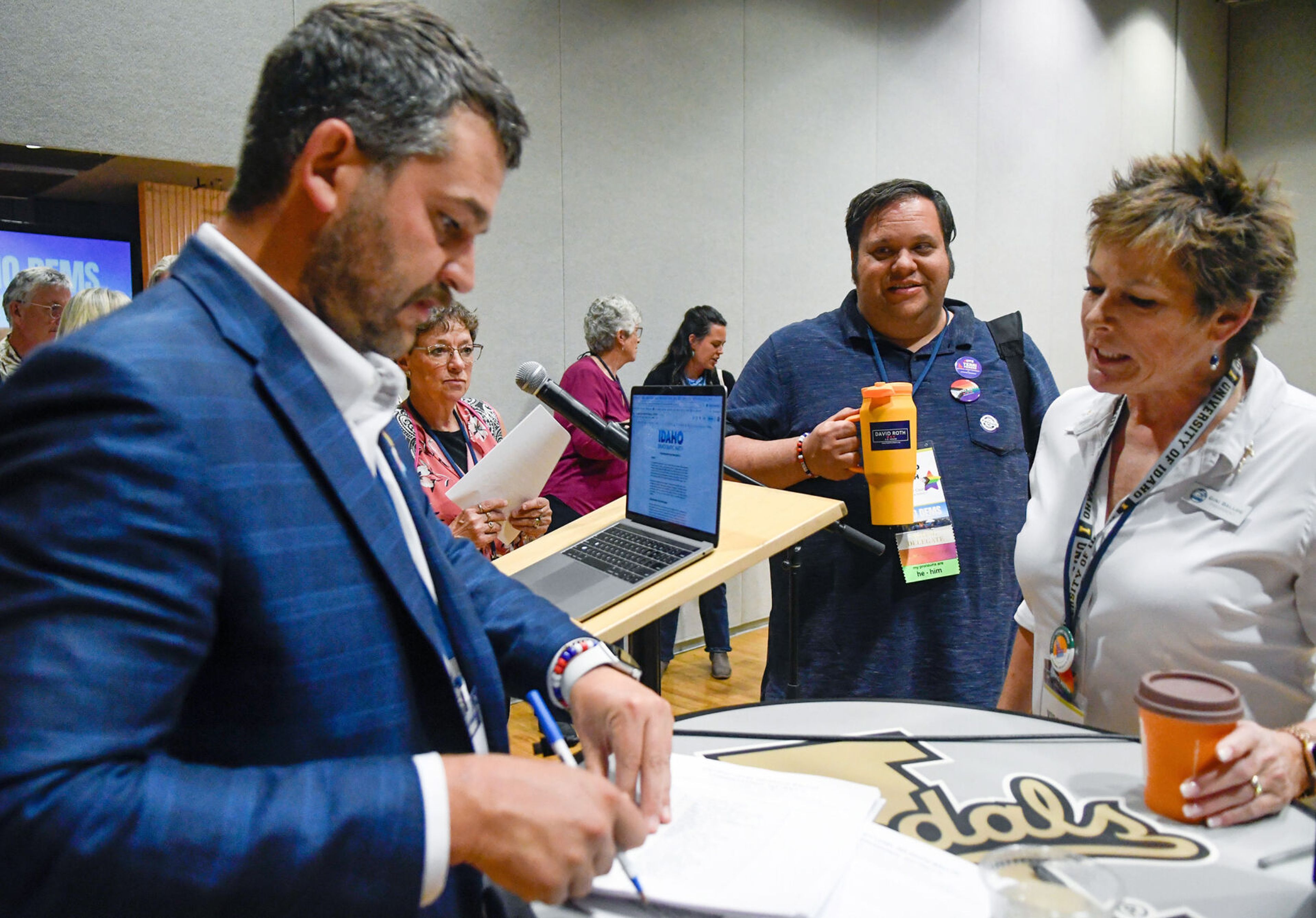 Jared DeLoof, left, executive director of the Idaho Democratic Party, hands out District Level Delegate Ballots to those gathered at the Idaho Democratic Convention, including Gini Ballou, right, of Lincoln County and a candidate for National Delegate, on Saturday in Moscow.