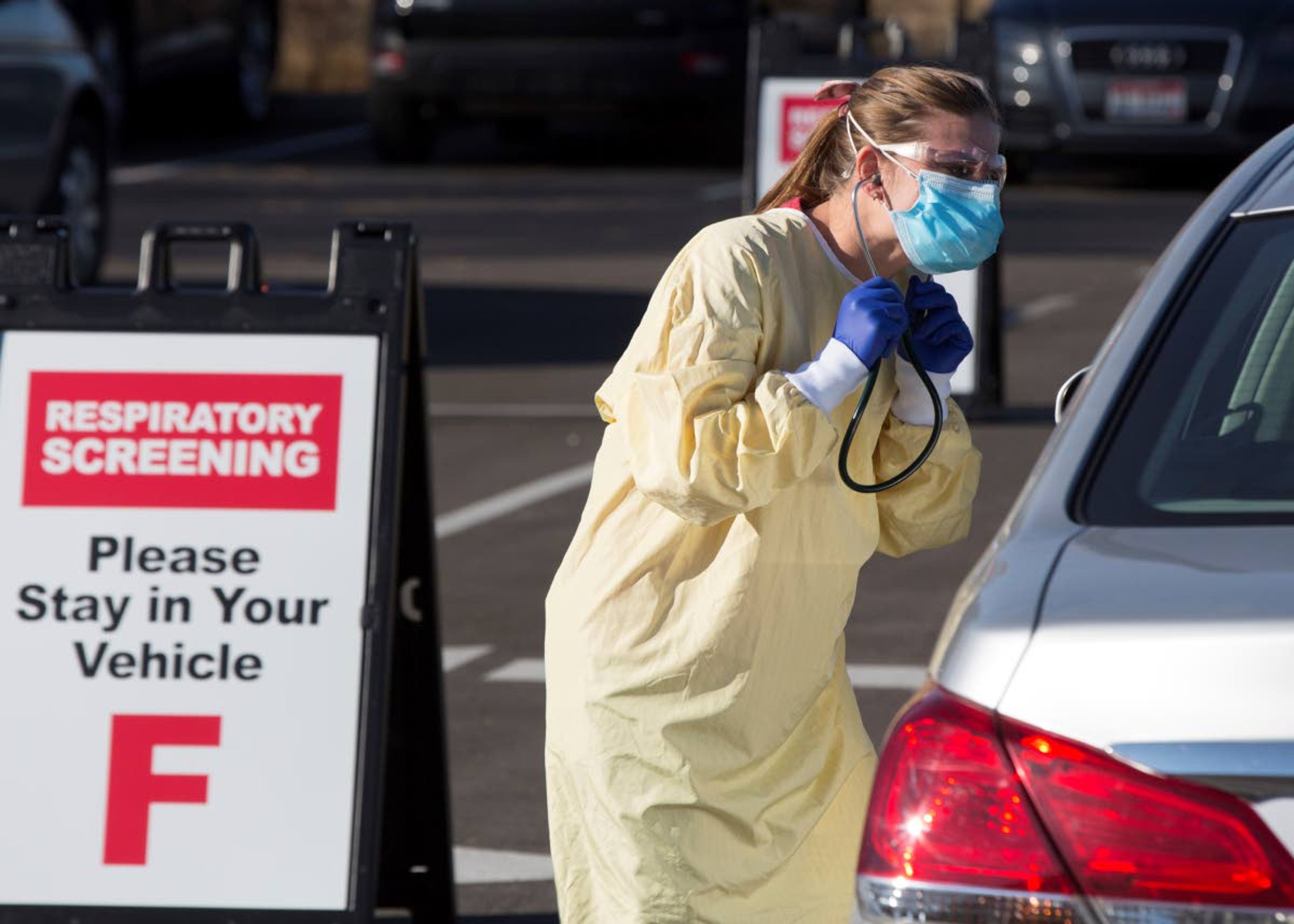 Physician assistant Nicole Thomas conducts a COVID-19 examination Nov. 24, 2020, in the parking lot at Primary Health Medical Group’s clinic in Boise.