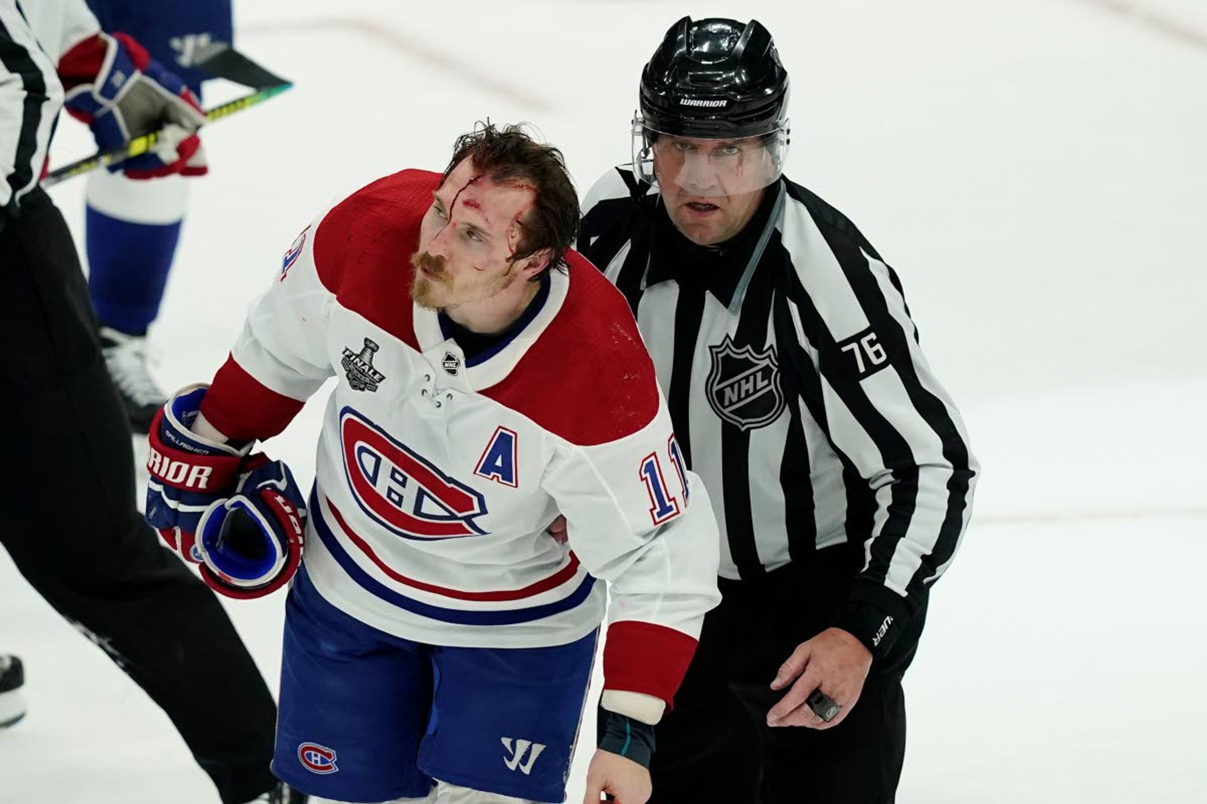 Montreal Canadiens right wing Brendan Gallagher (11) skates off the ice with linesman Michel Cormier (76) after a fight during the third period in Game 1 of the NHL hockey Stanley Cup finals against the Tampa Bay Lightning, Monday, June 28, 2021, in Tampa, Fla. (AP Photo/Gerry Broome)